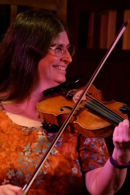 Laurie Hart playing the fiddle with a smile