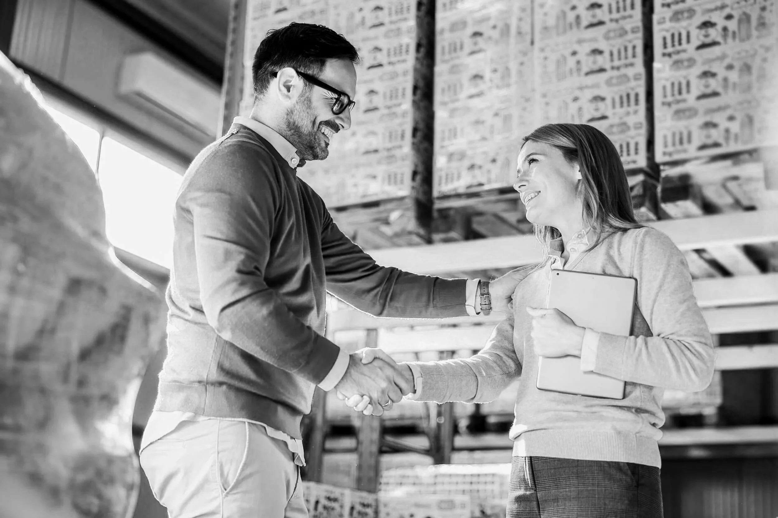 Young emerging female leader shaking hands with a trade customer in a warehouse setting