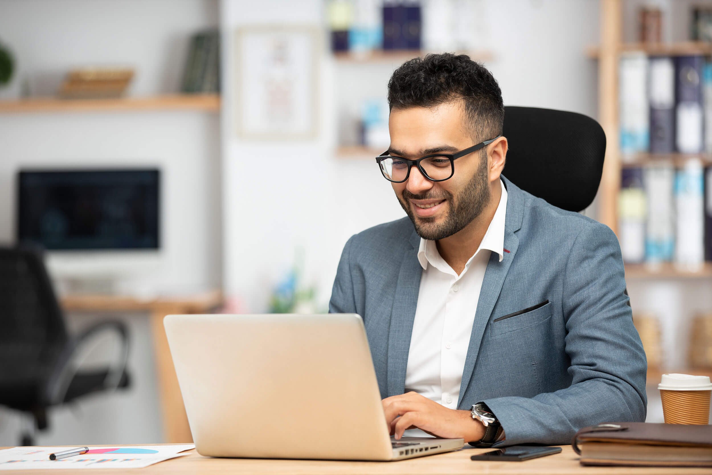 Sales leader sitting at his desk completing the Values & Attributes compass on his laptop