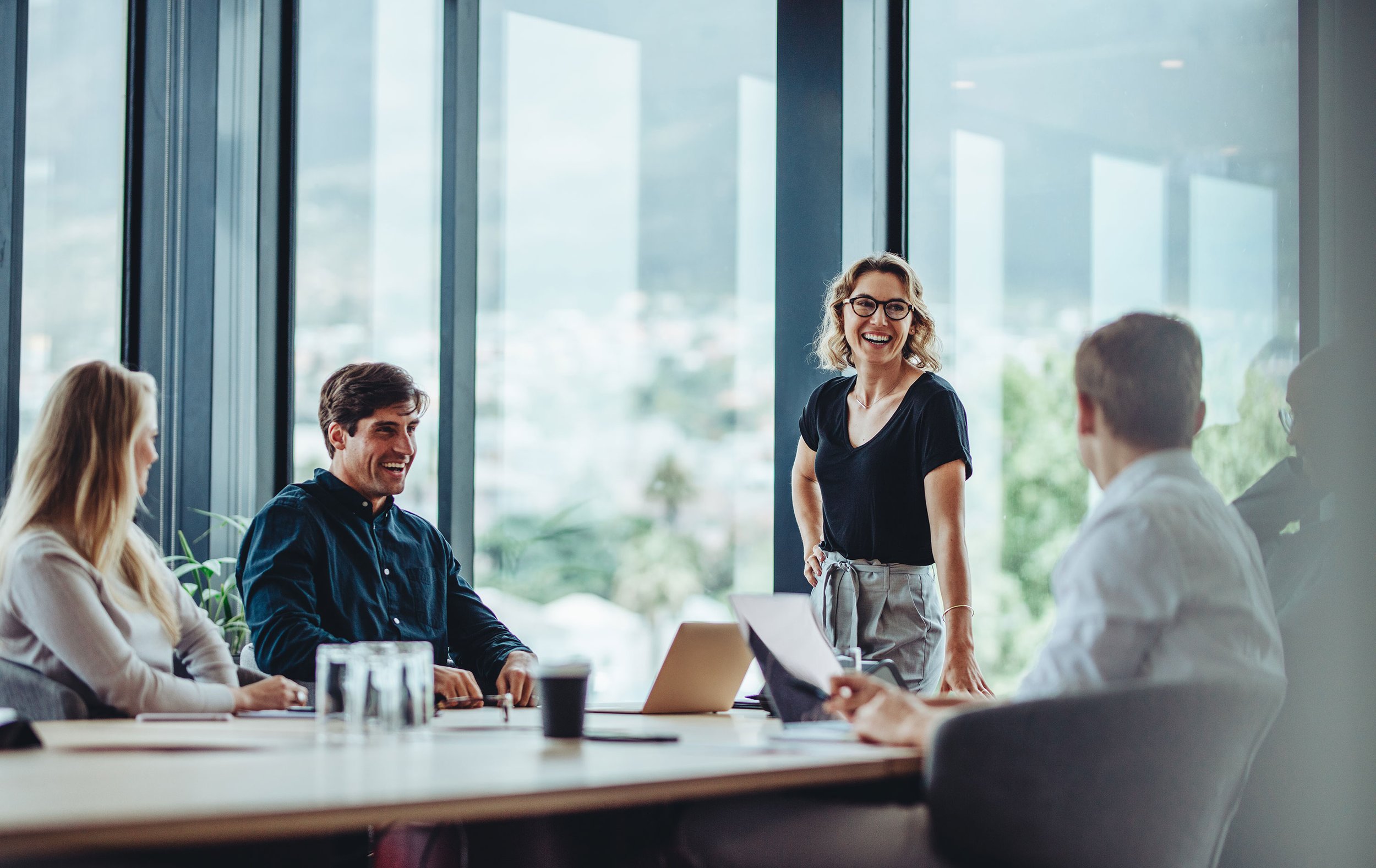 Confident business team leader talking to her team around table