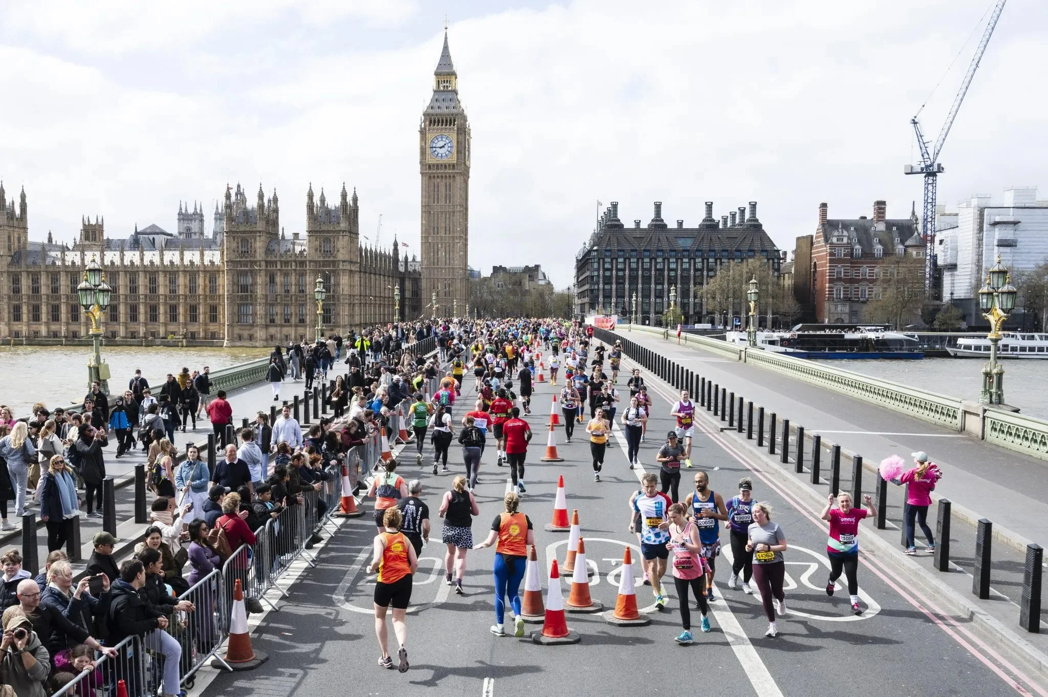 People participating in a marathon in a city street with historic buildings, including St. Paul's Cathedral, in the background.