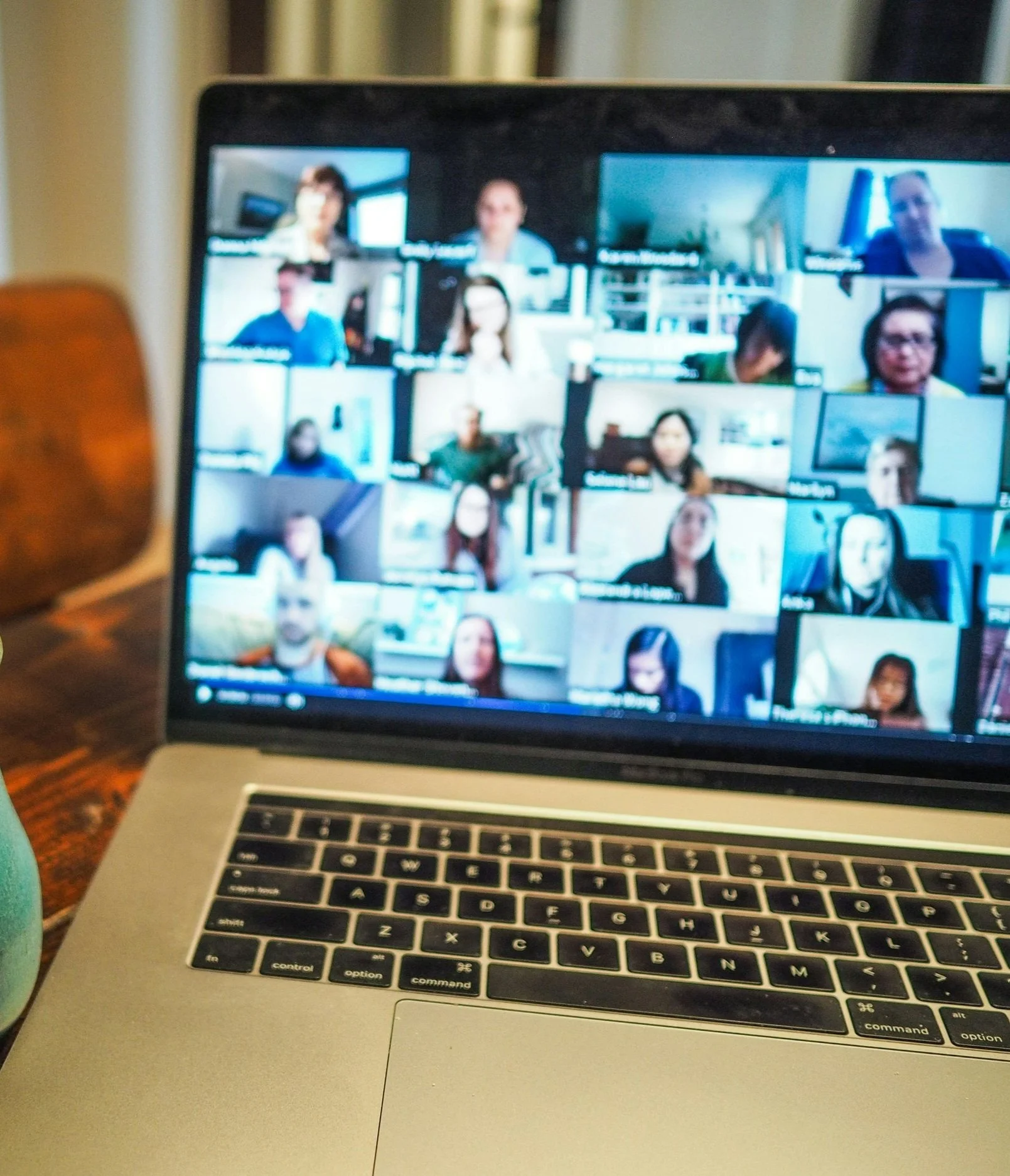 Laptop screen displaying a video conference with multiple participants.