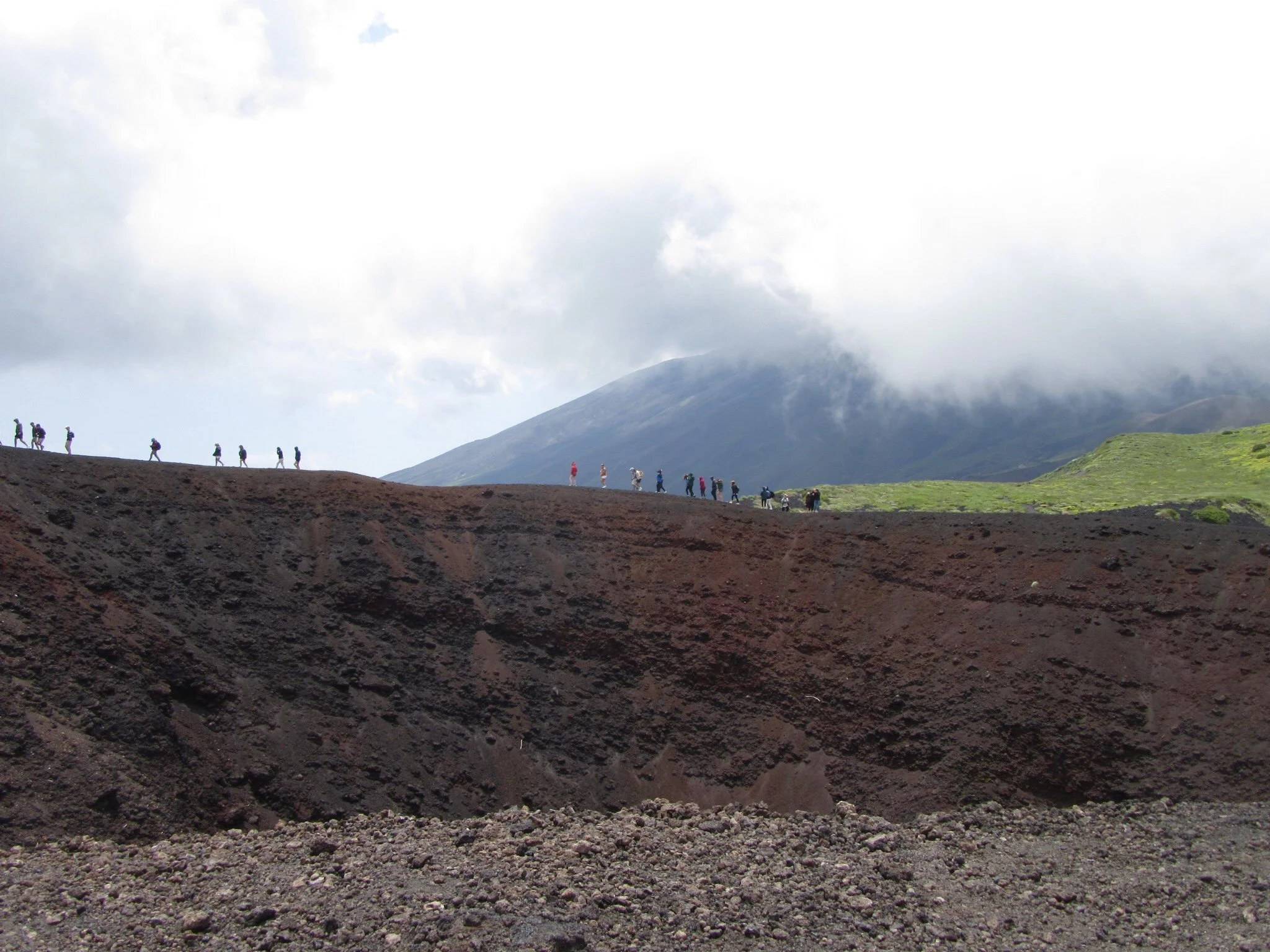 Tour groups walking around one of Mount Etna's craters in Sicily.