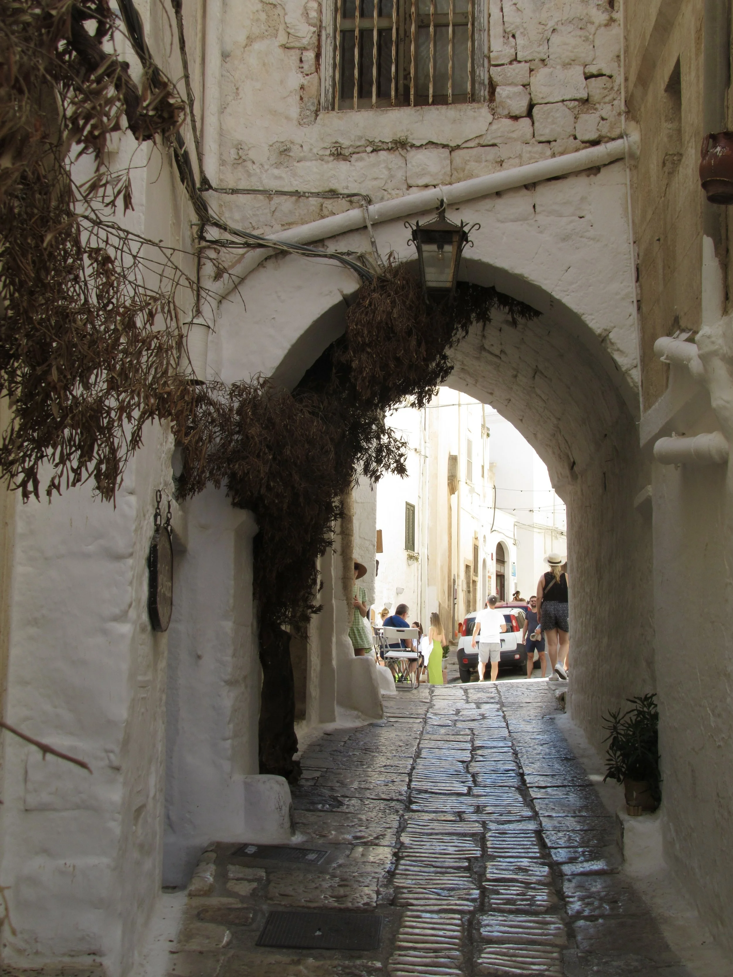 A white-washed, stone archway on a street in Ostuni, Puglia.