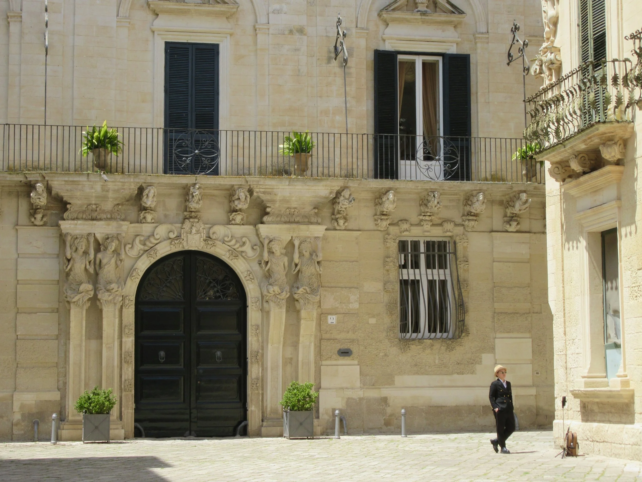 A well-dressed young man standing in an empty piazza in Lecce, Puglia.