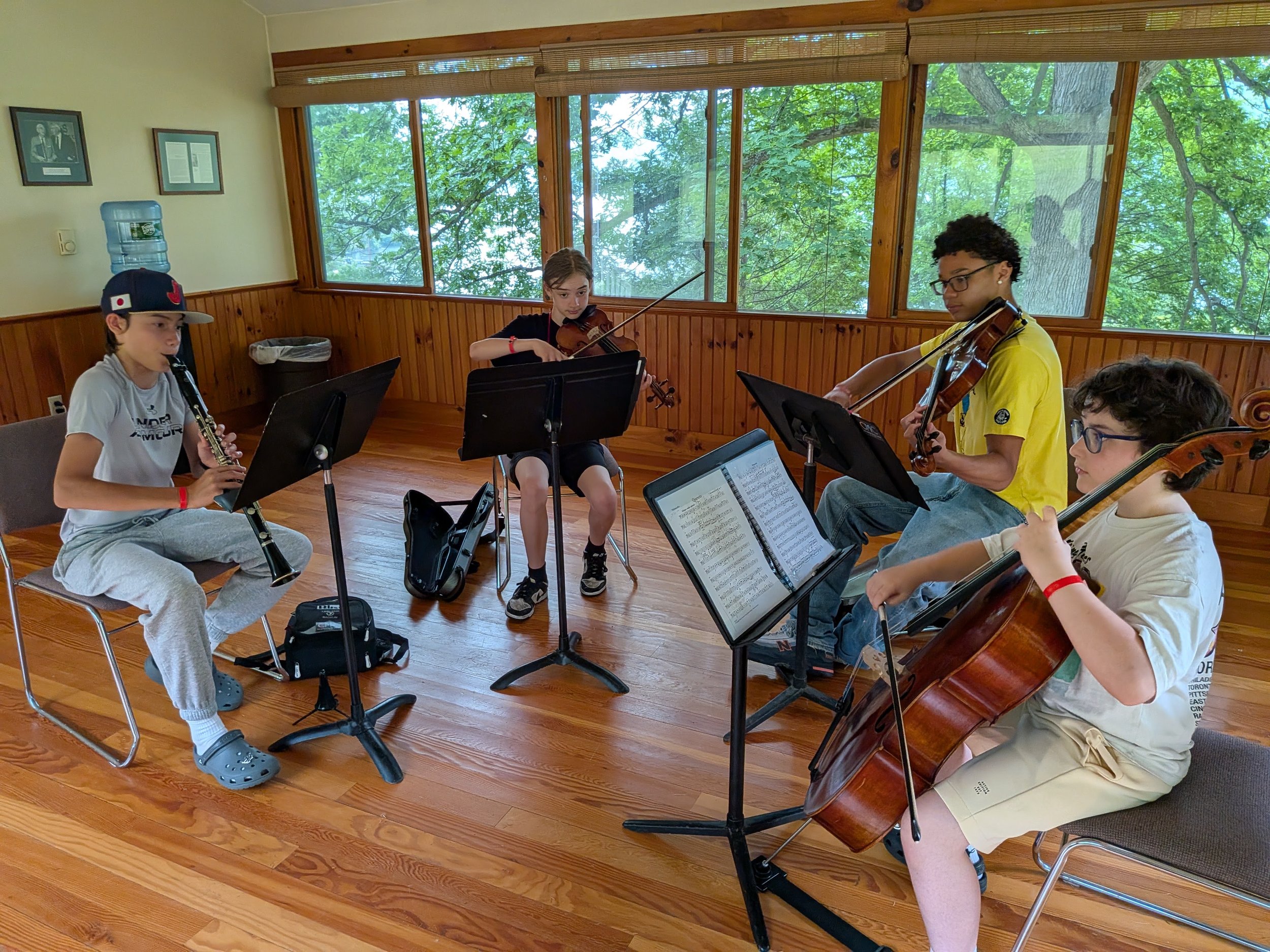 Young string players during chamber music group coaching session with instructor.