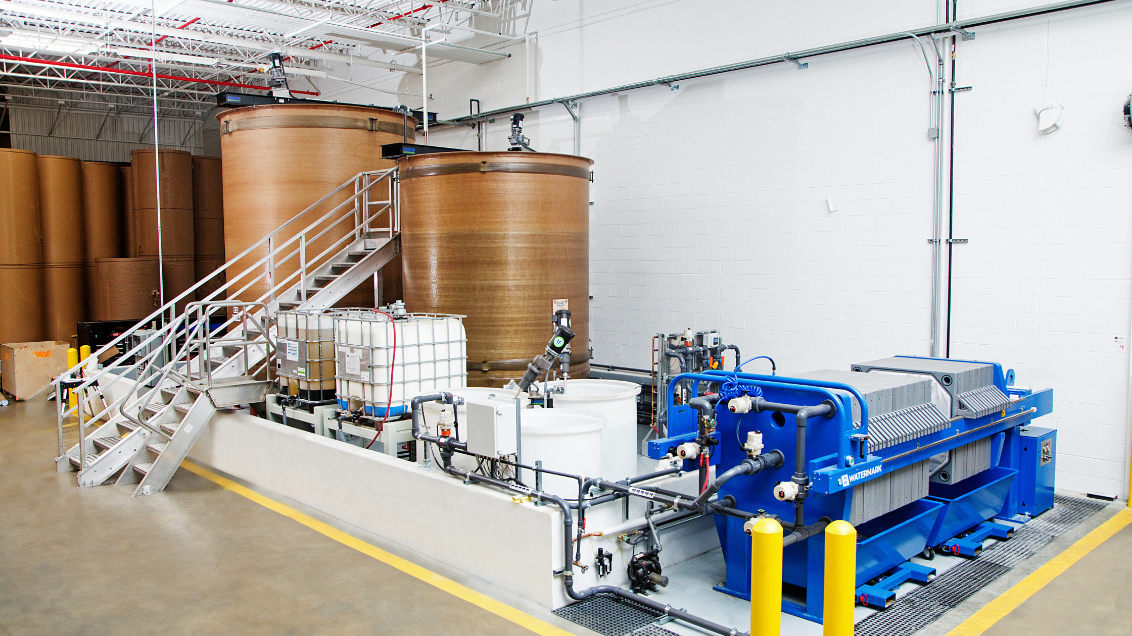 Walla Walla Environmental's waste water treatment system.  The image shows two treatment tanks, two ladders, and product in totes that are used to treat the water.