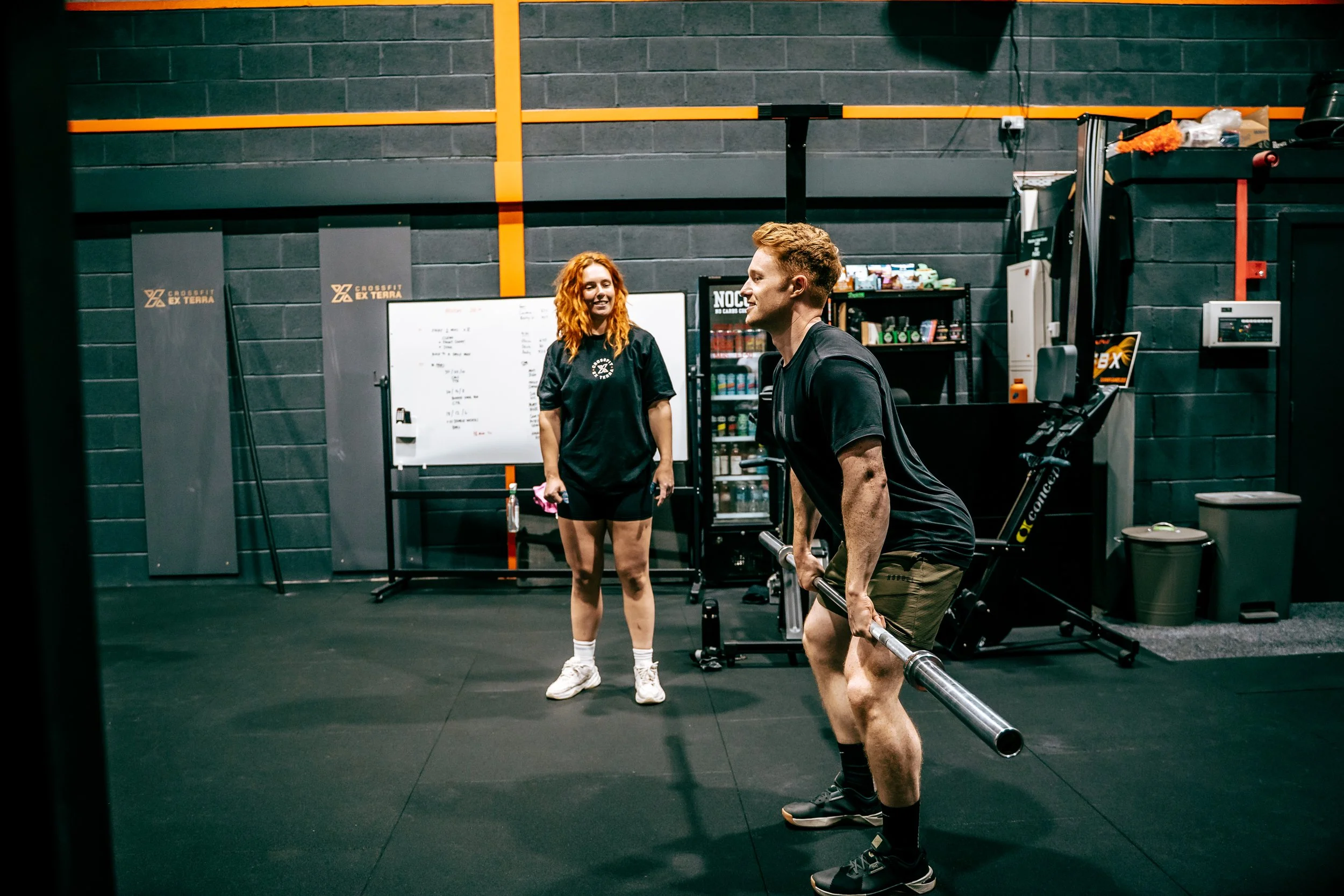 Member lifting a barbell with a coach watching at CrossFit Ex Terra, St Helens