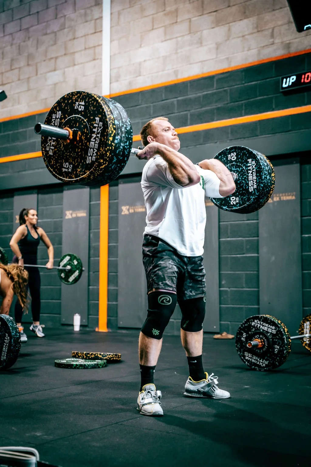 Man lifting a barbell in a group class at CrossFit Ex Terra, St Helens