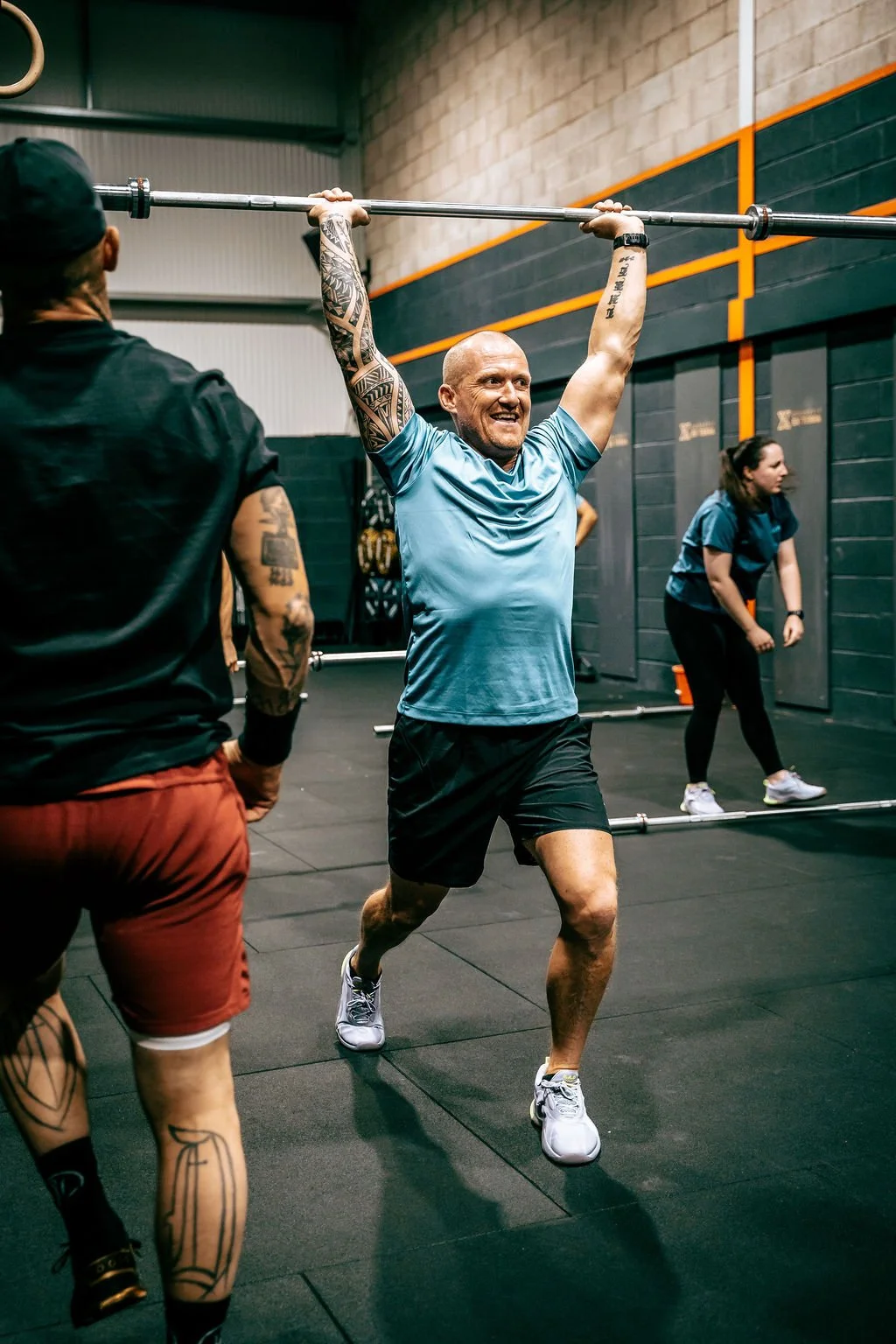 Man lifting a barbell overhead during a CrossFit class