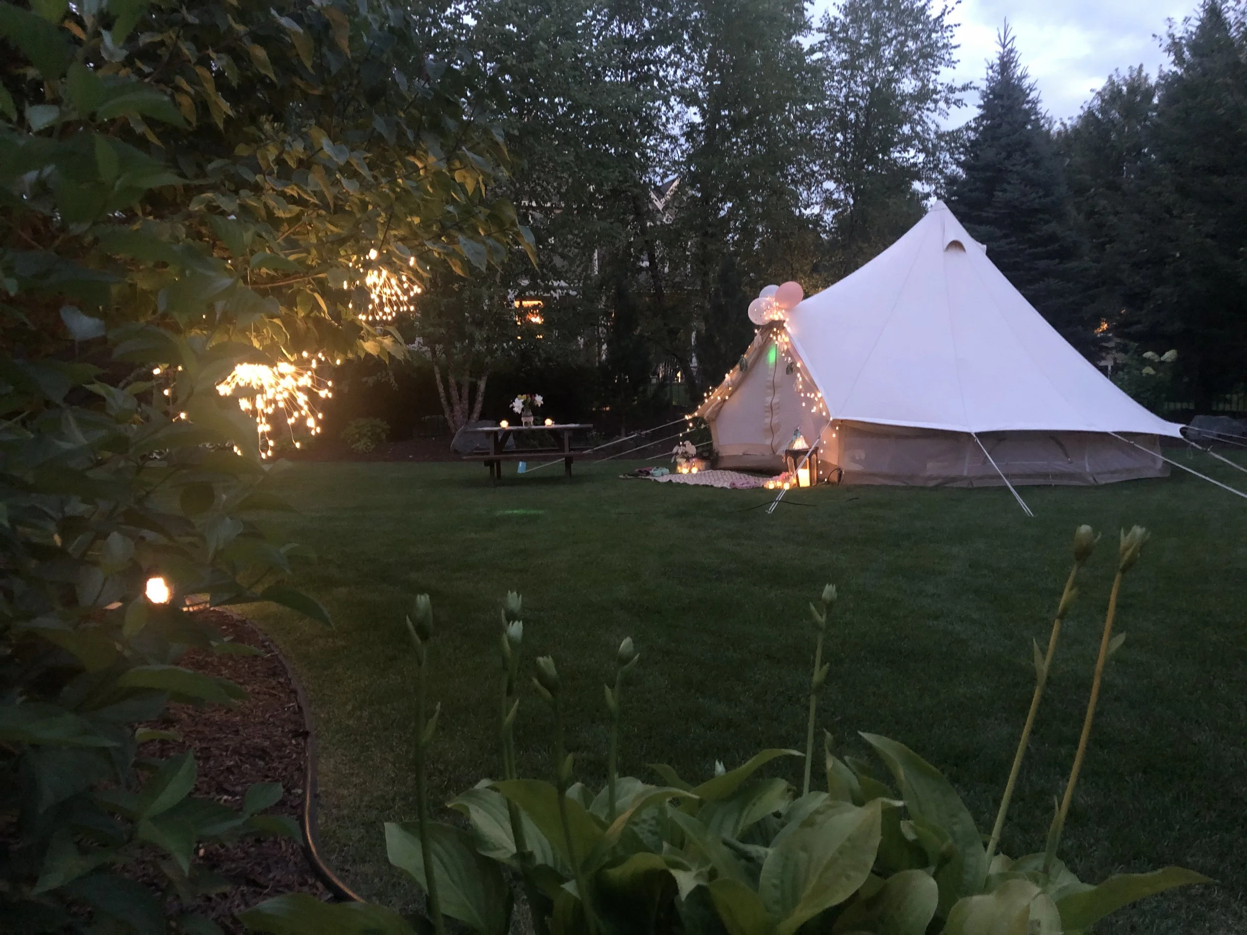 Wedding tent rental illuminated with string lights for an evening outdoor wedding in Virginia