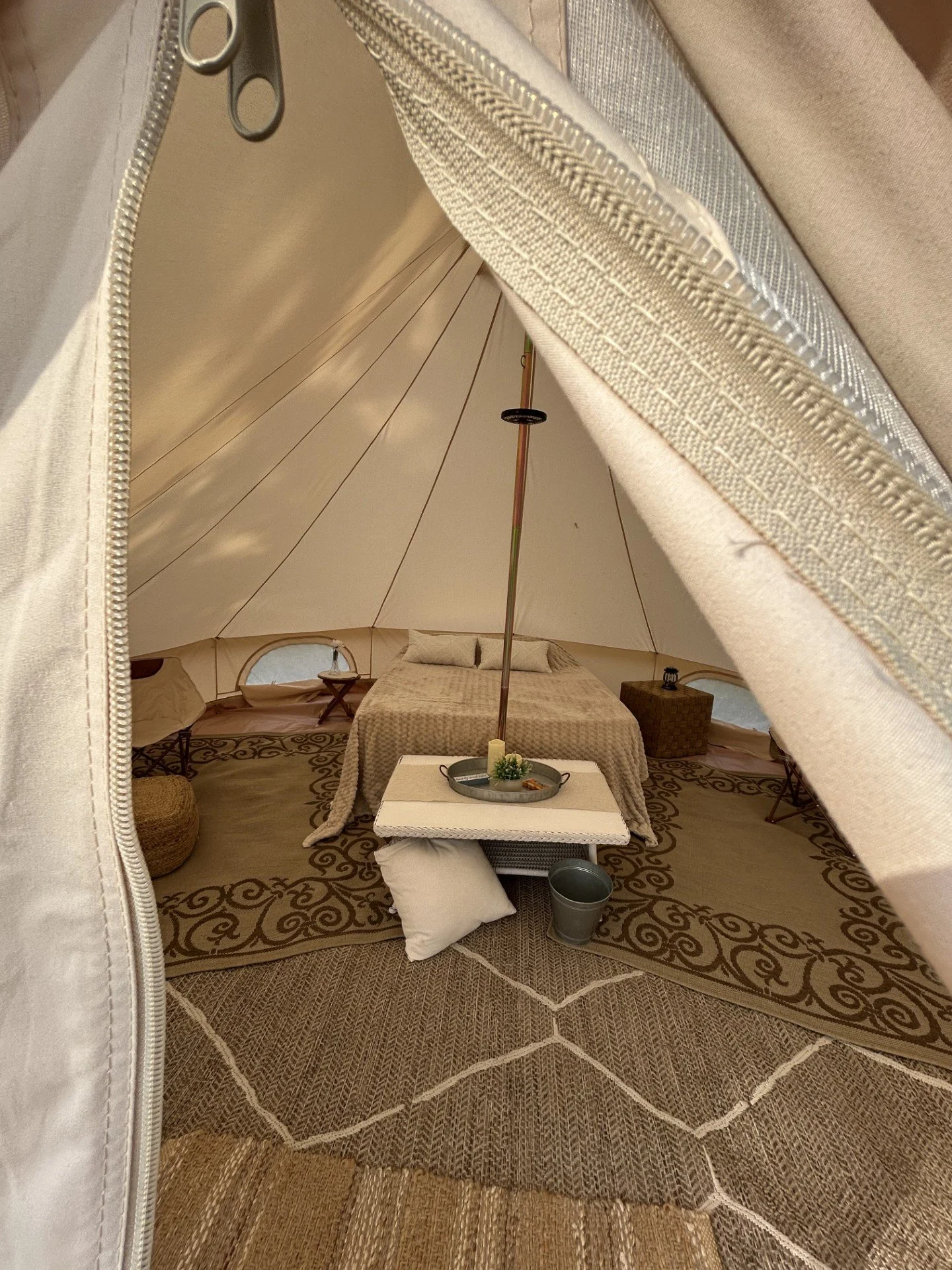 Styled interior of a festival tent with bedding and soft lighting