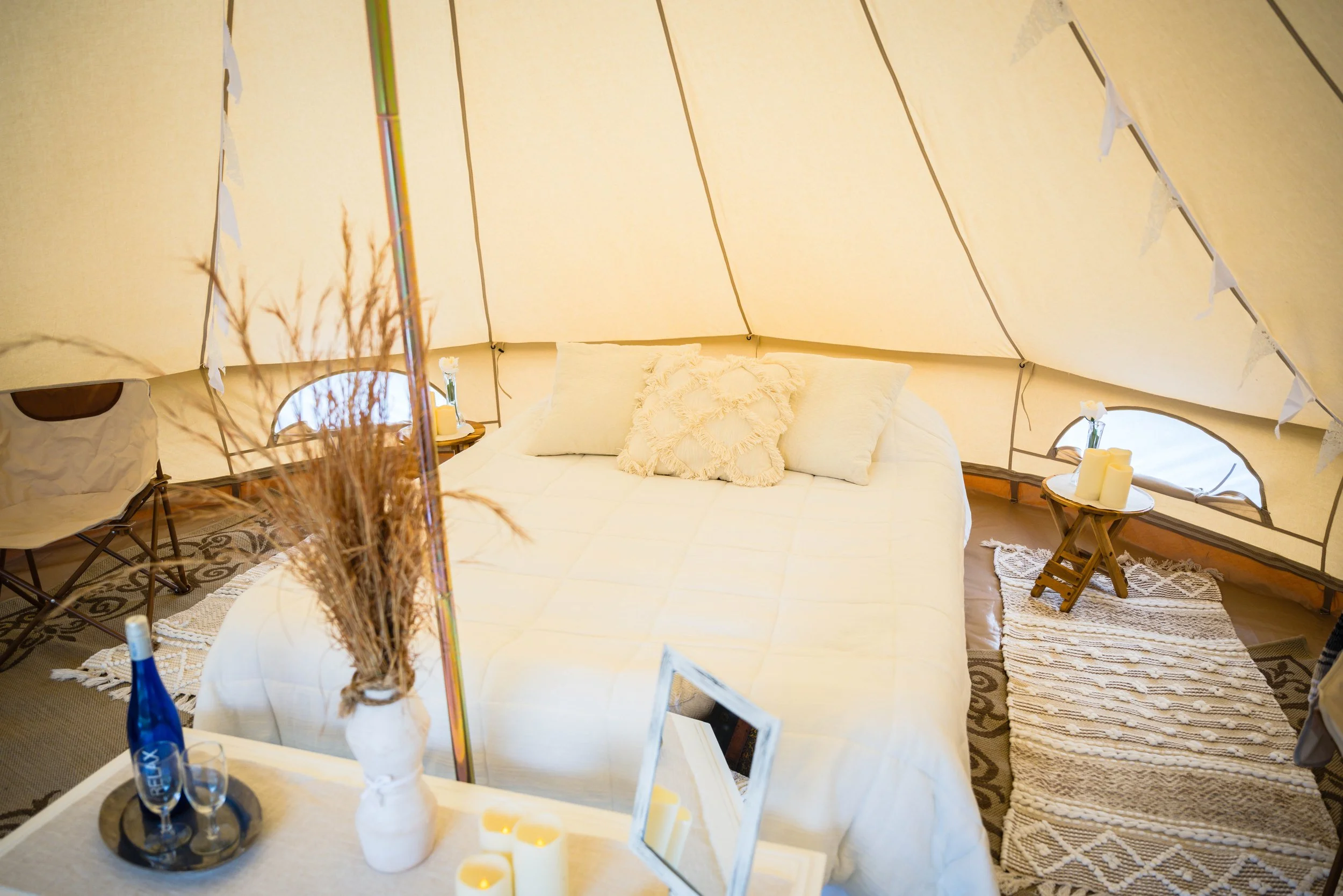 luxury wedding glamping tent with cozy bedding and soft lighting