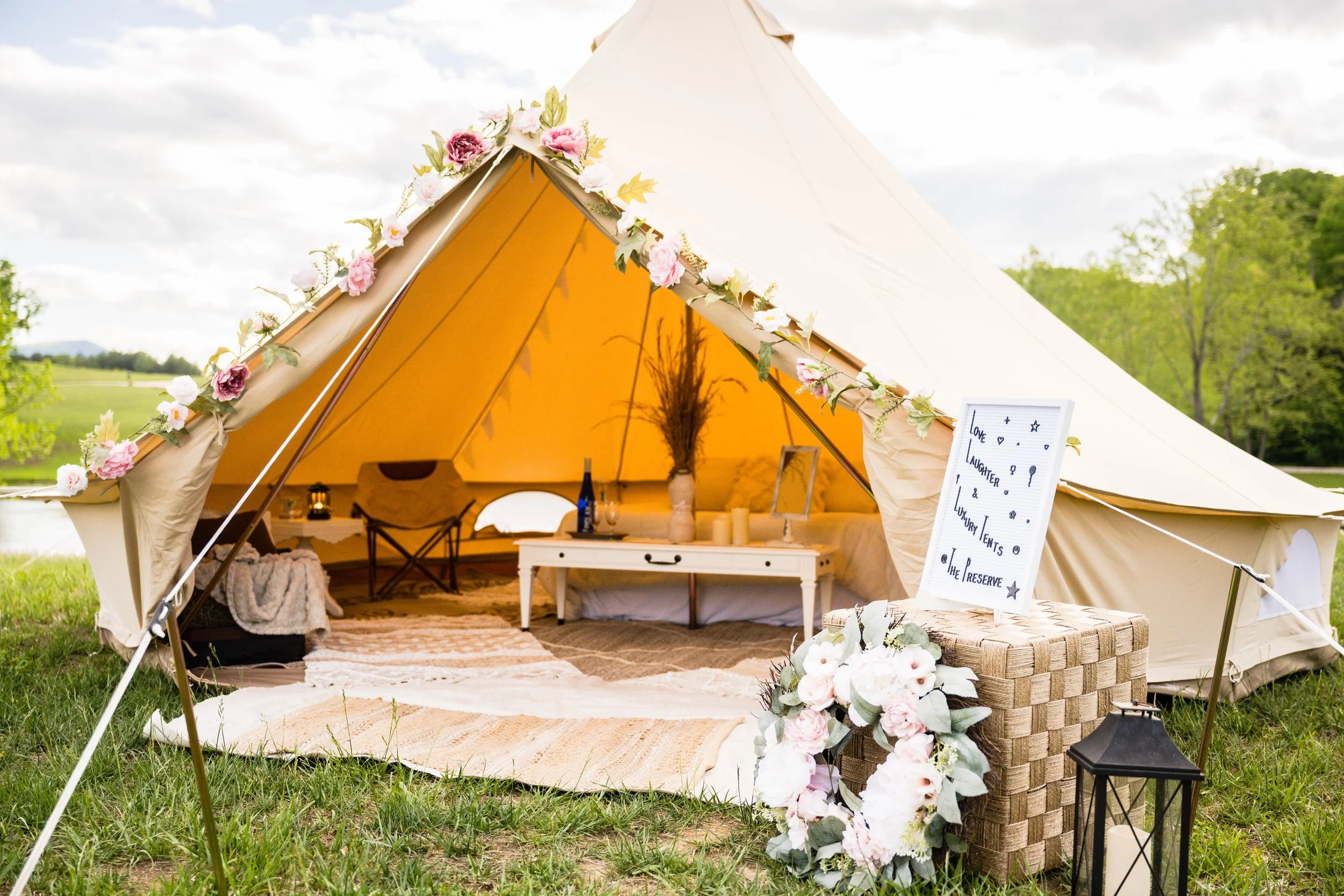 Outdoor luxury wedding glamping tent with interior view showing cozy bedding and décor