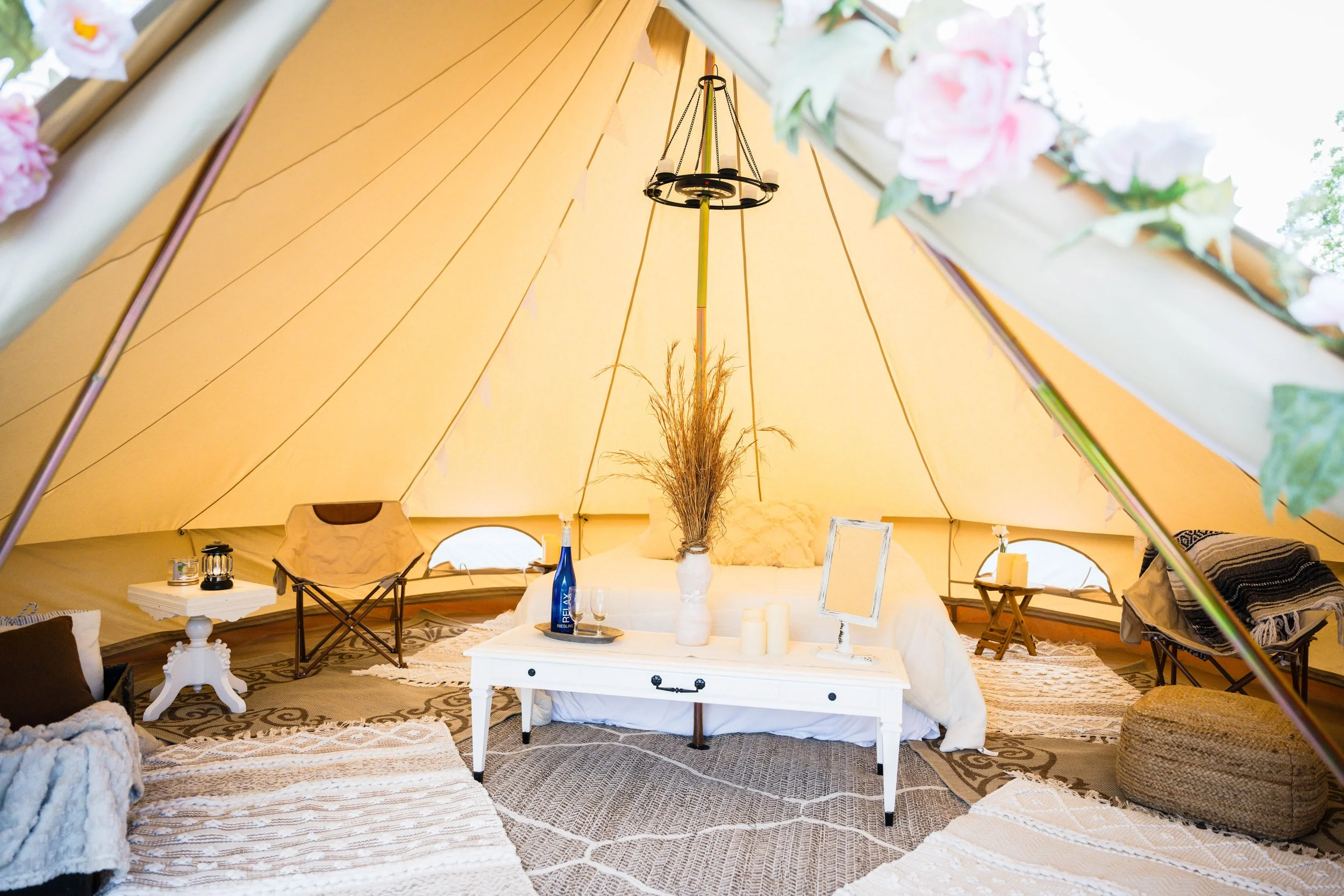Interior of a wedding tent rental styled for comfort and relaxation on the wedding day