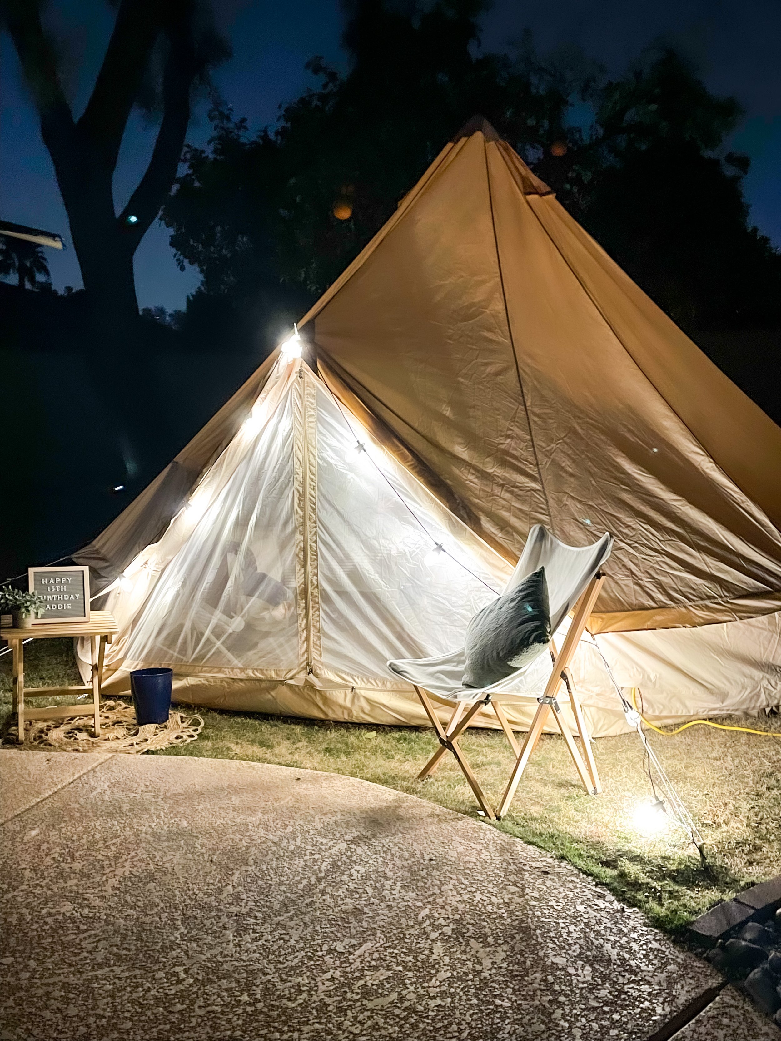 Evening family gathering in a glamping tent with warm string lighting and cozy seating