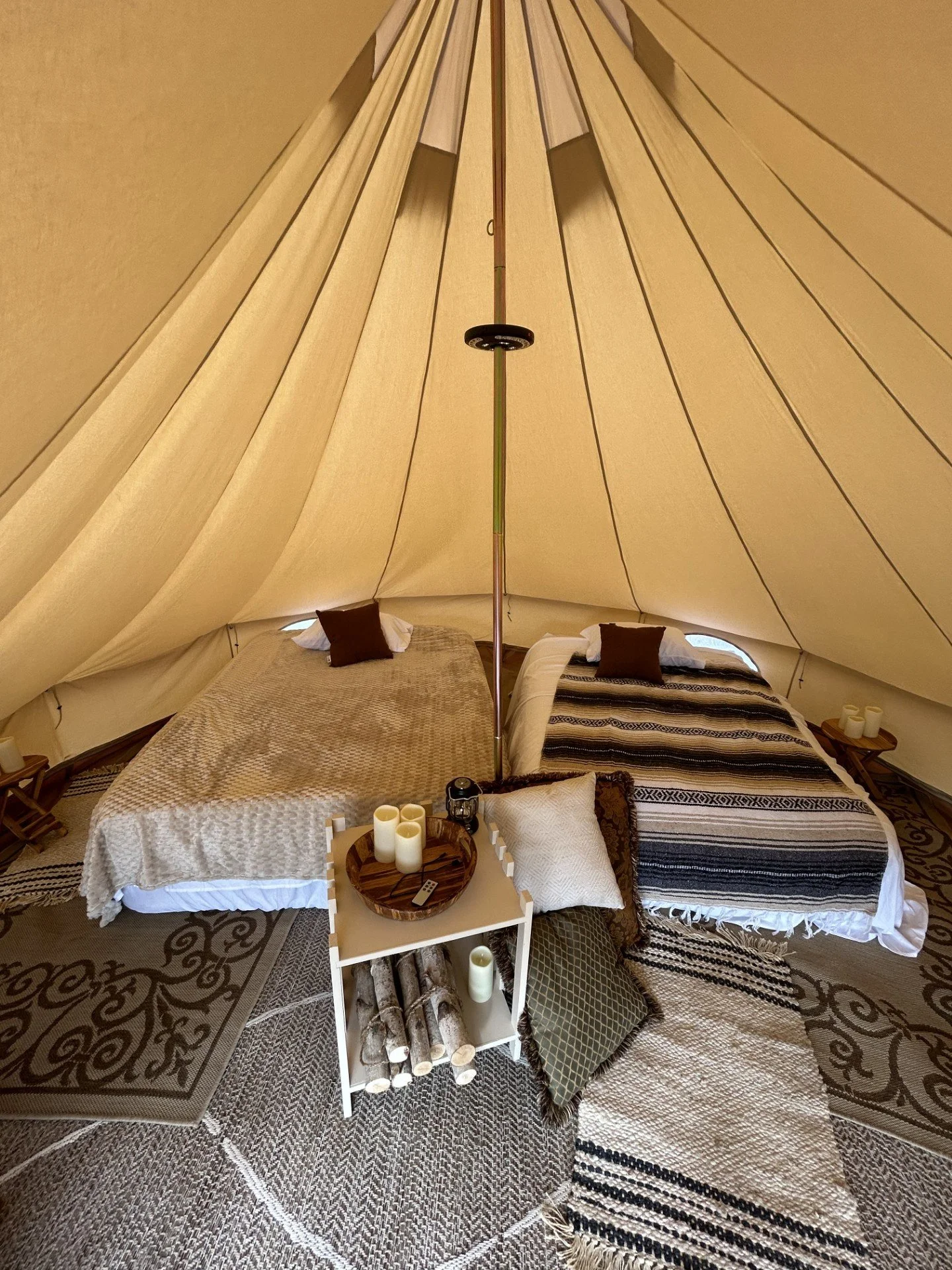 Styled interior of a luxury glamping tent featuring a queen bed in a backyard setting in Roanoke, VA