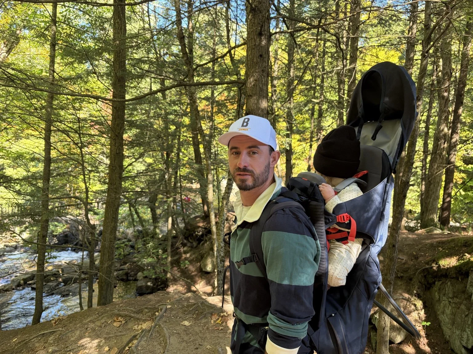 Blair Wilson hiking with his child in a backpack carrier.
