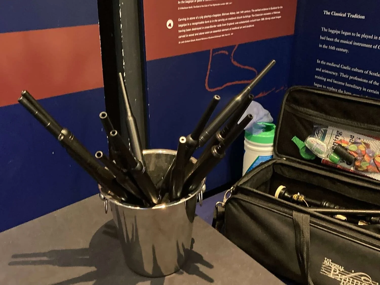 a silver bucket with several bagpipe chanters for museum visitors to try