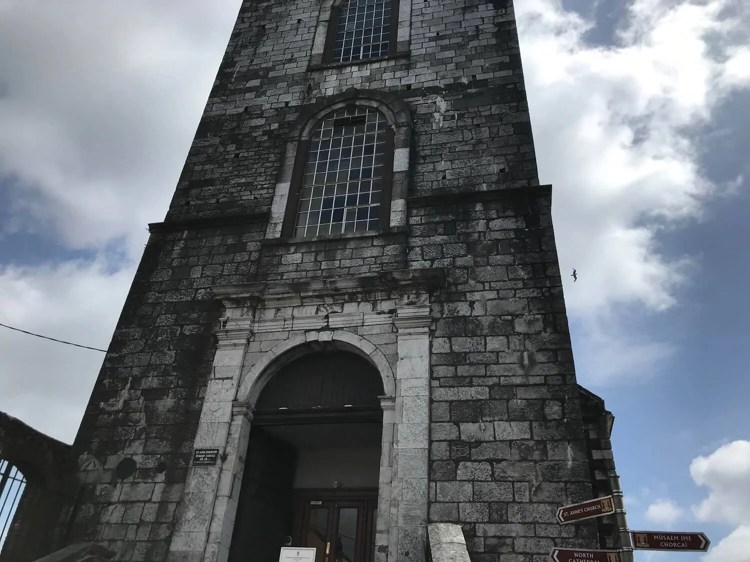 gray stone church below a blue sky with clouds