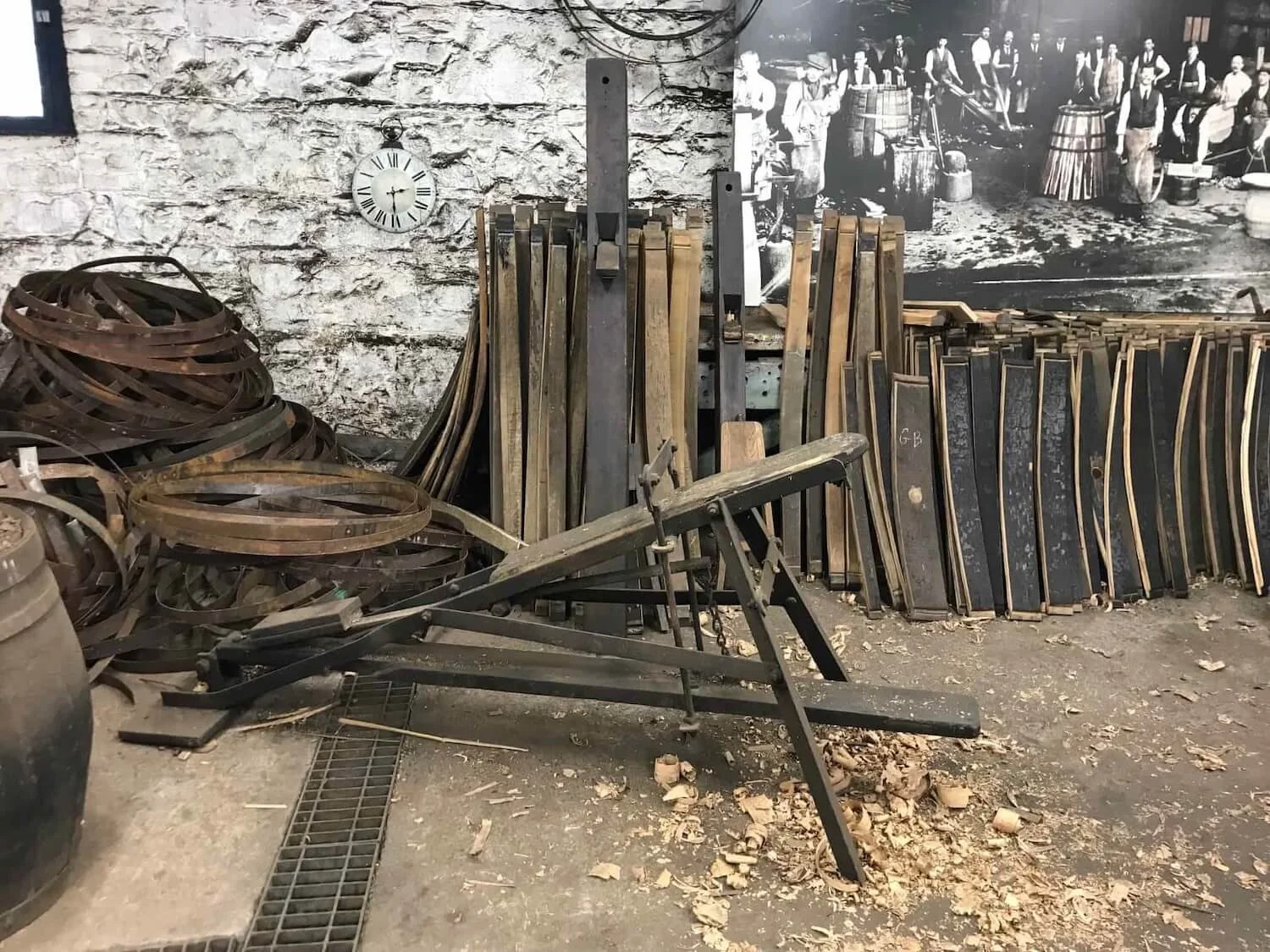 cooperage supplies with in front of a stone wall with wood shavings on the ground