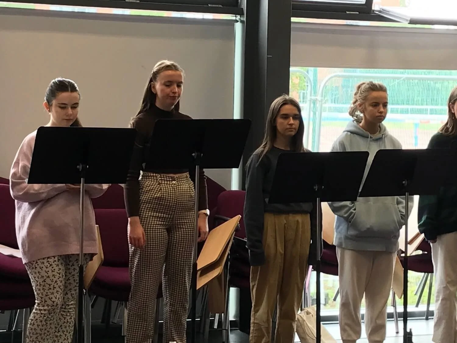 four young women reading music on music stands