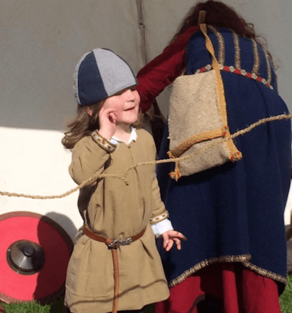 young boy wearing a viking hat and smiling