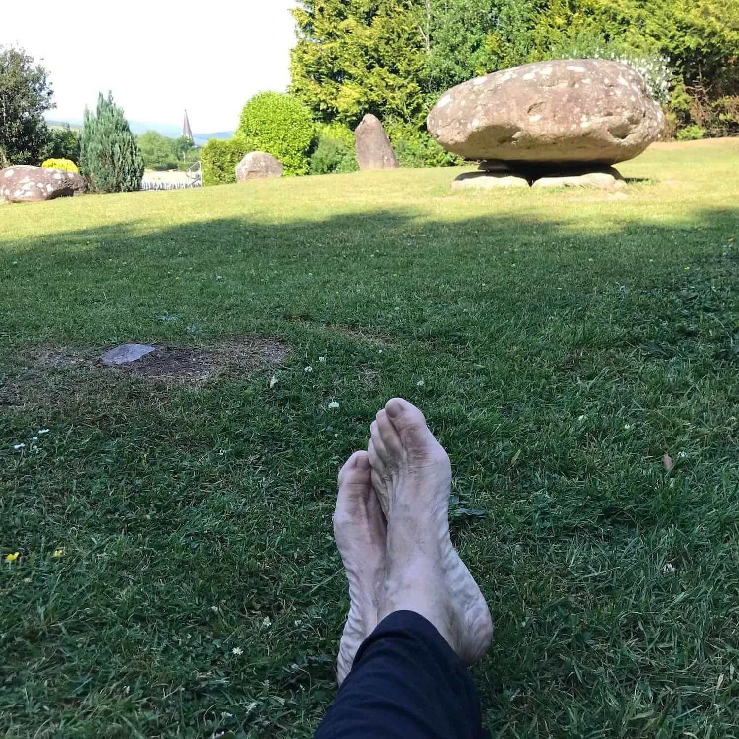 bare feet on grass in front of the stone circle