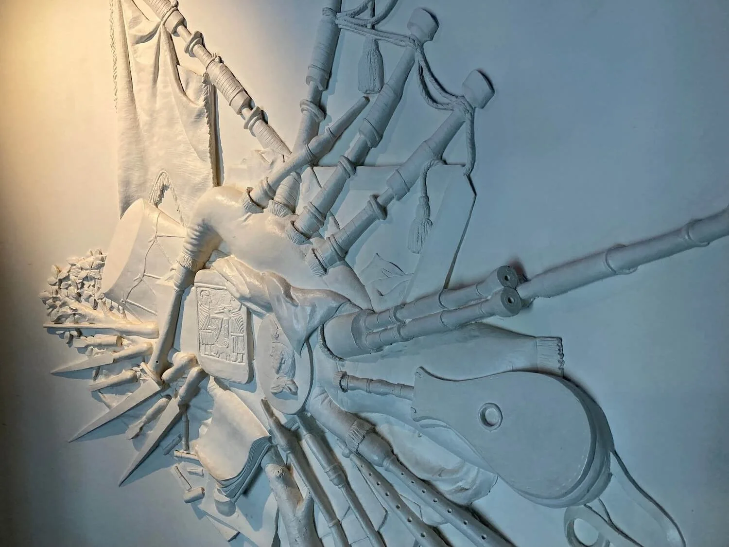 carved bagpipes on white wall