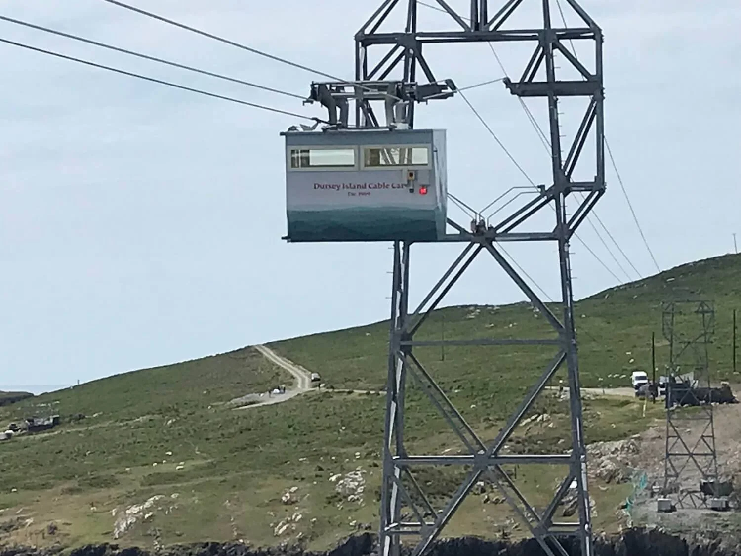 Cable Car moving above green hill in Ireland
