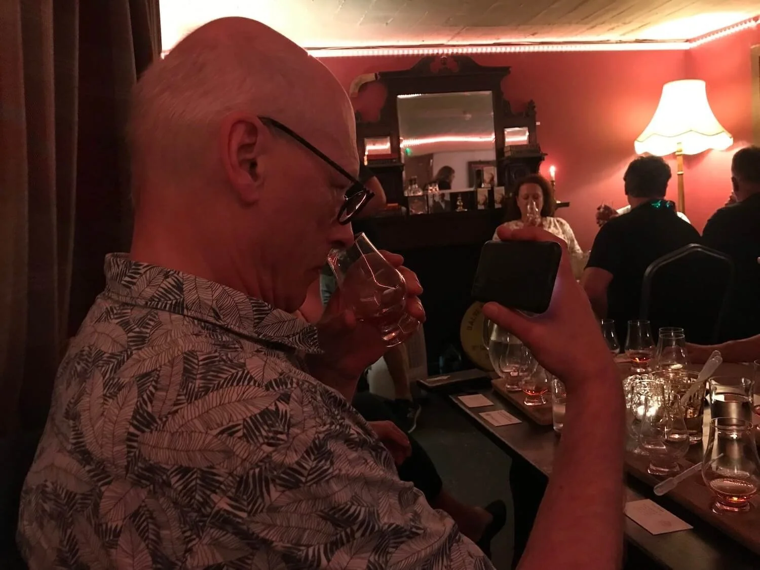 man sniffing scottish whiskey from a glass in a whiskey tasting room