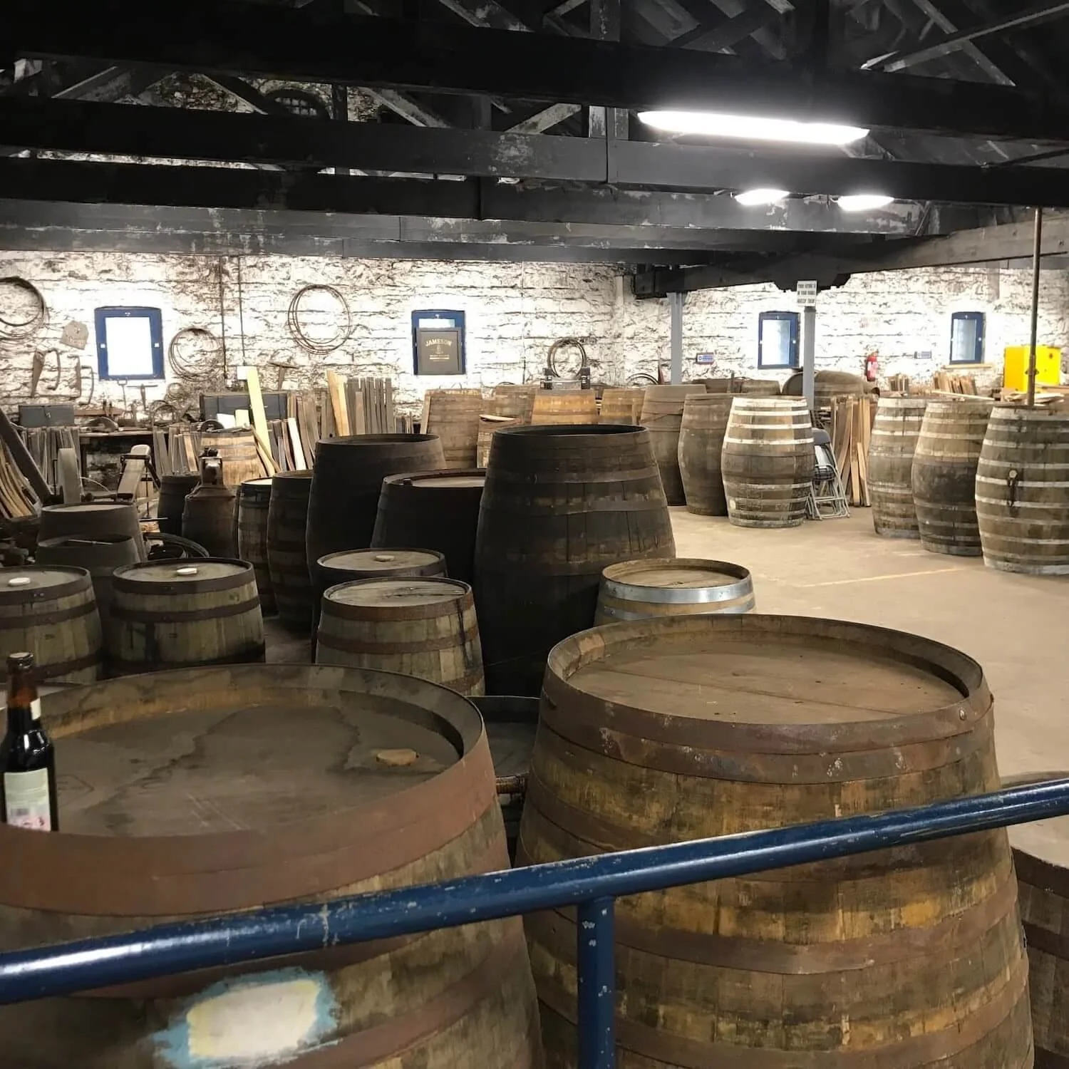 Jameson casked stored in a stone-walled room with black ceiling beams