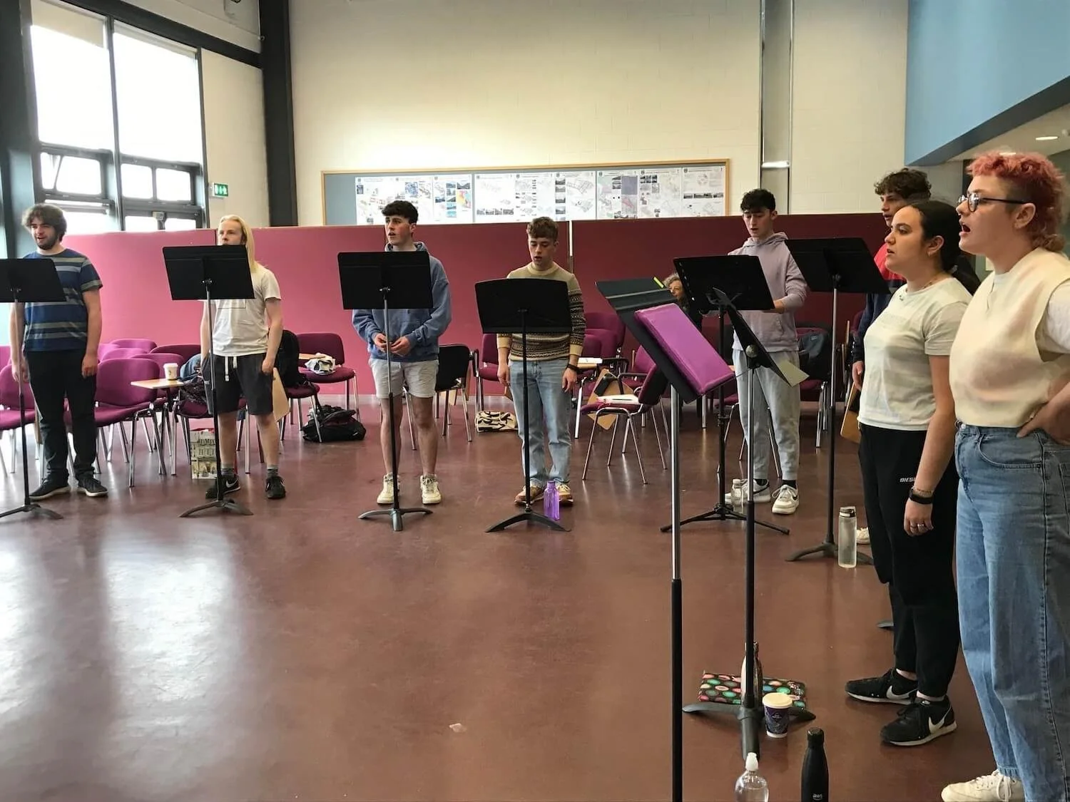 choral scholars standing in front of music stands singing