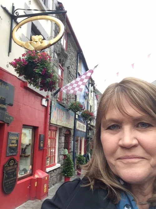 Erin Breen standing in front of a red storefront on an Irish street