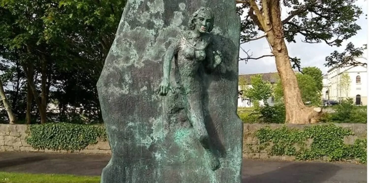 statue with woman emerging from the stone