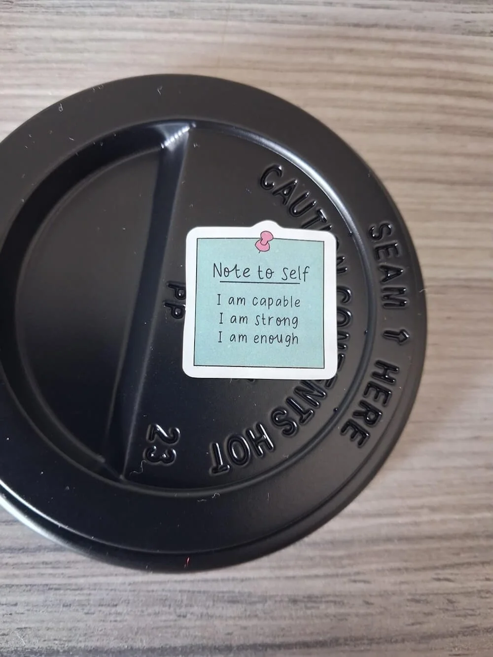 coffee cup lid with a sticker reading note to self I am capable, I am strong, I am enought