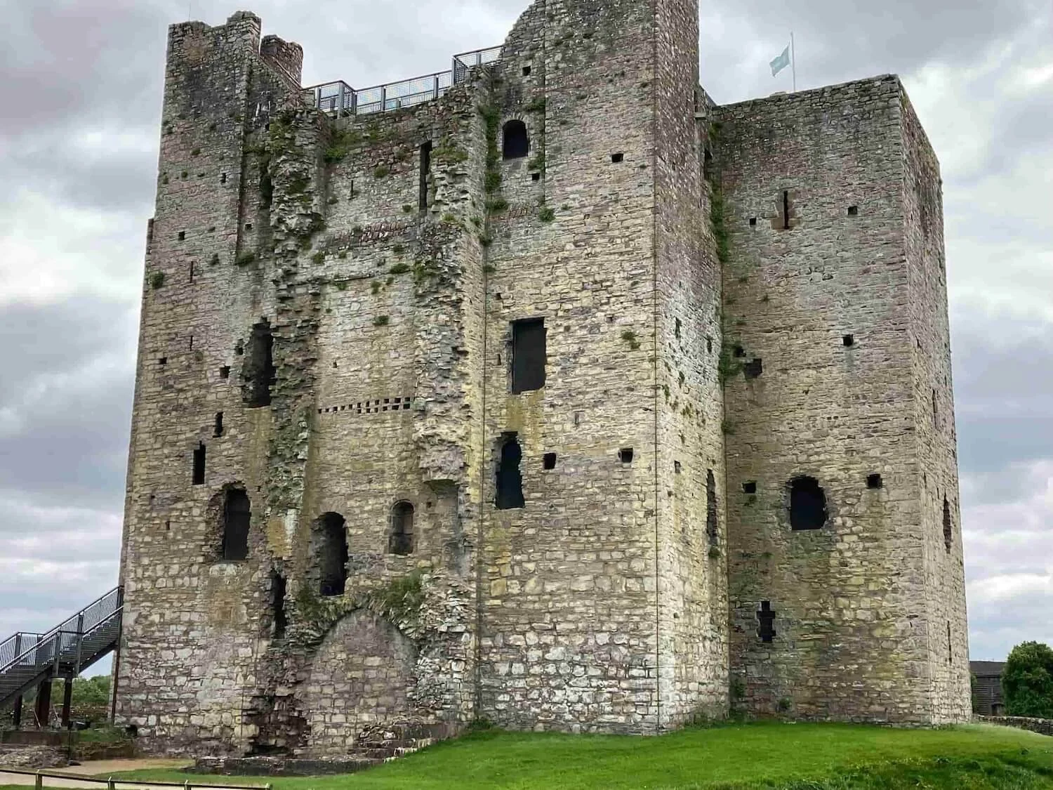 trim castle rising above a green lawn into a cloudy sky