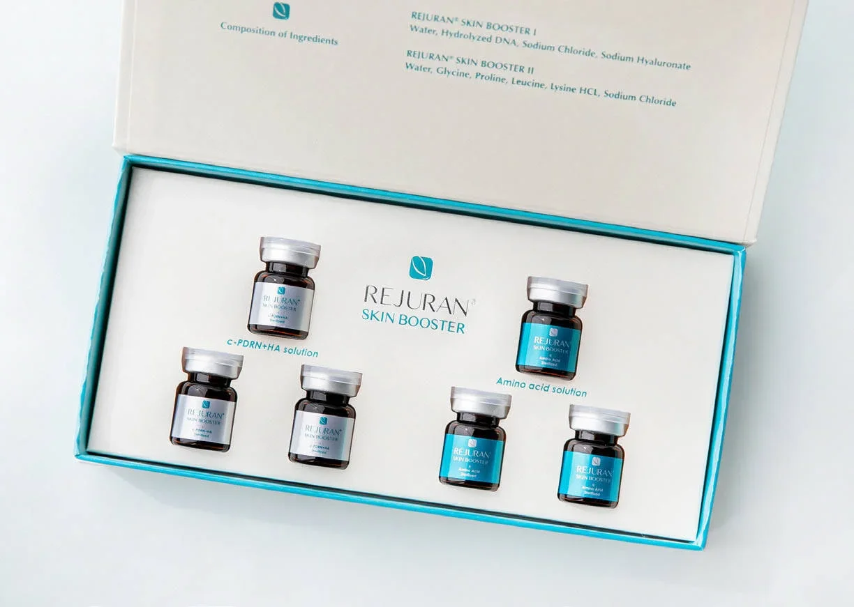 Open box of Rejuran skin booster vials with six small bottles inside, label visible on each, package describing ingredients and purpose in background.