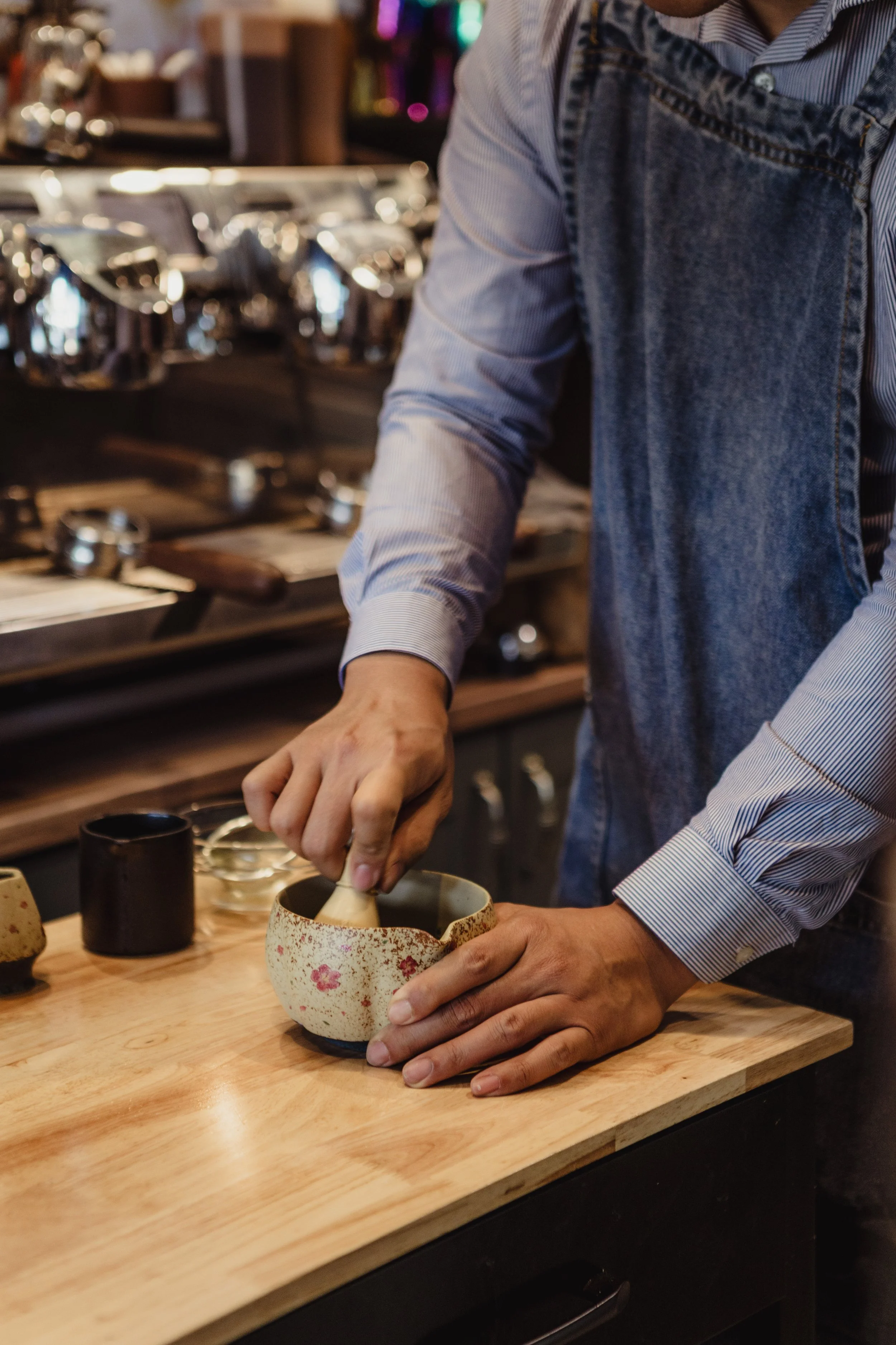 A man is whisking matcha on a bench