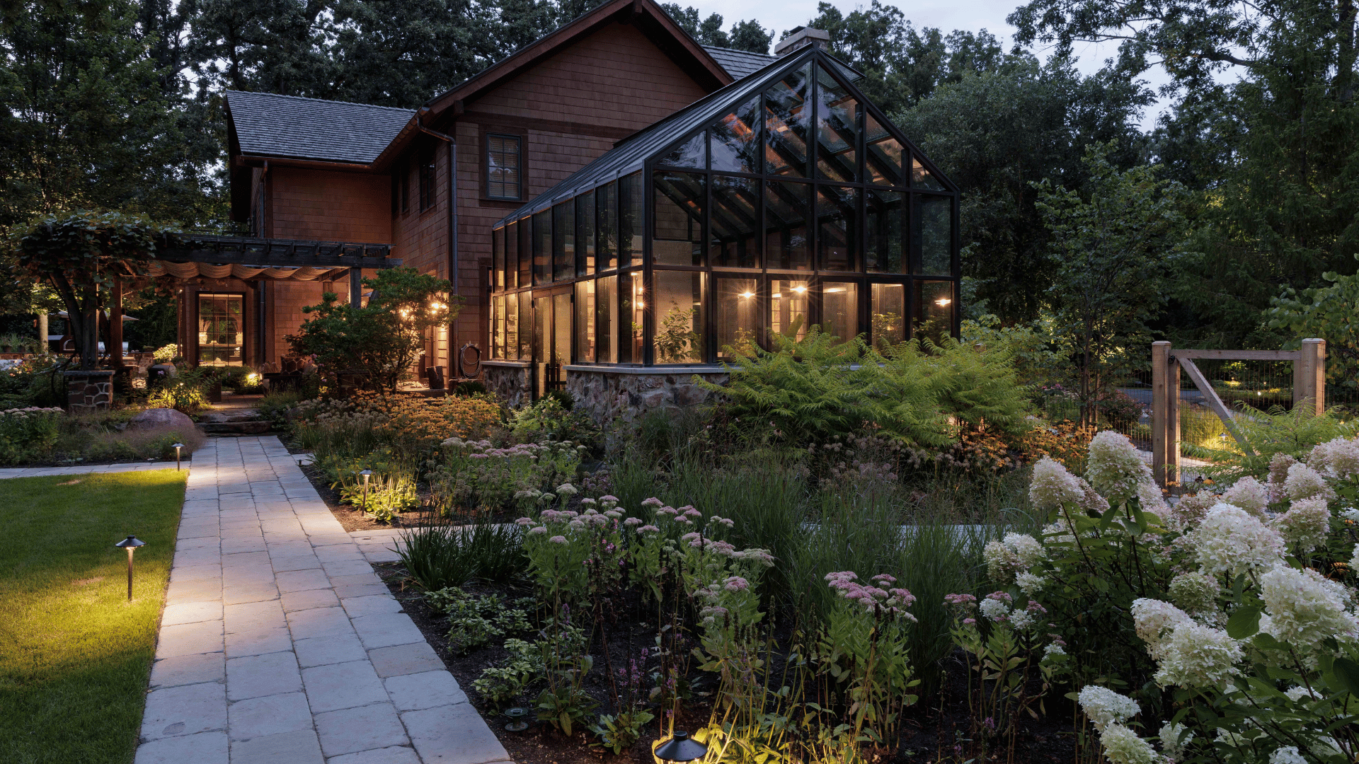Riverwoods IL Glass Greenhouse Landscape Lighting Curved Paver Walkway Dusk pappas company construction landscape design