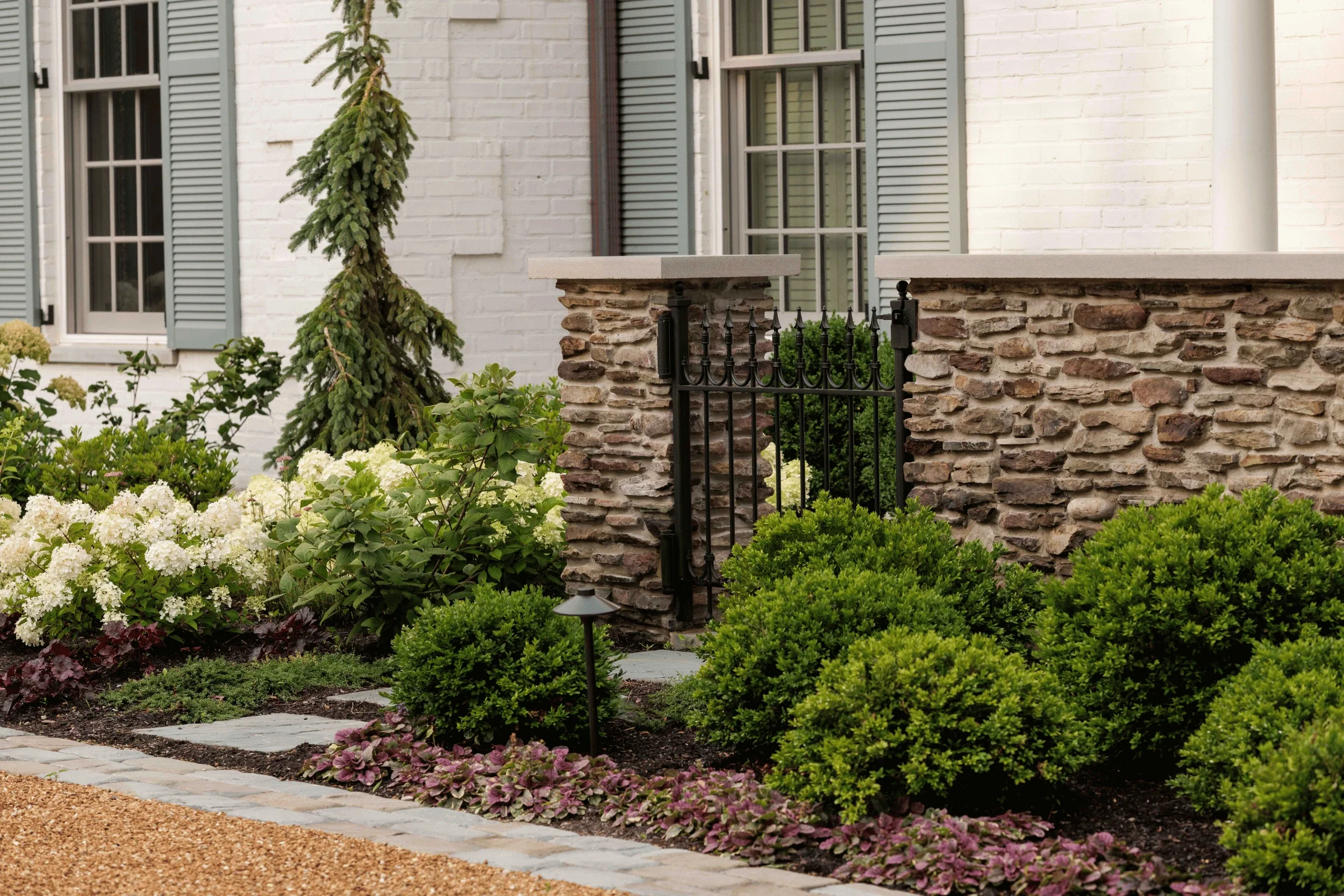 hardscaping-natural-stone-garden-wall-wrought-iron-gate-north-shore-pappas-company-landscape.webp