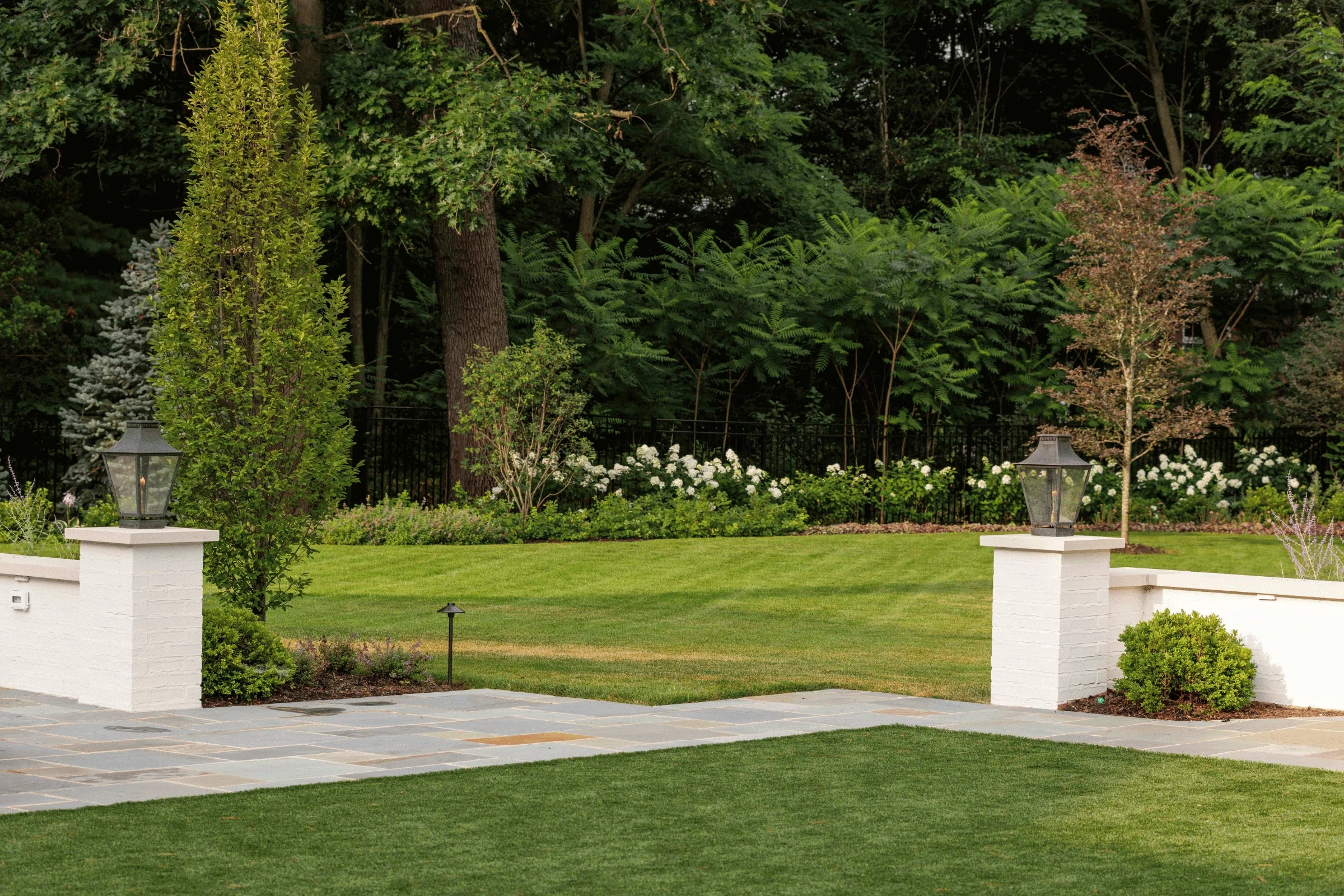 hardscaping-bluestone-patio-brick-seat-walls-gas-lanterns-north-shore-pappas-company-landscape.webp