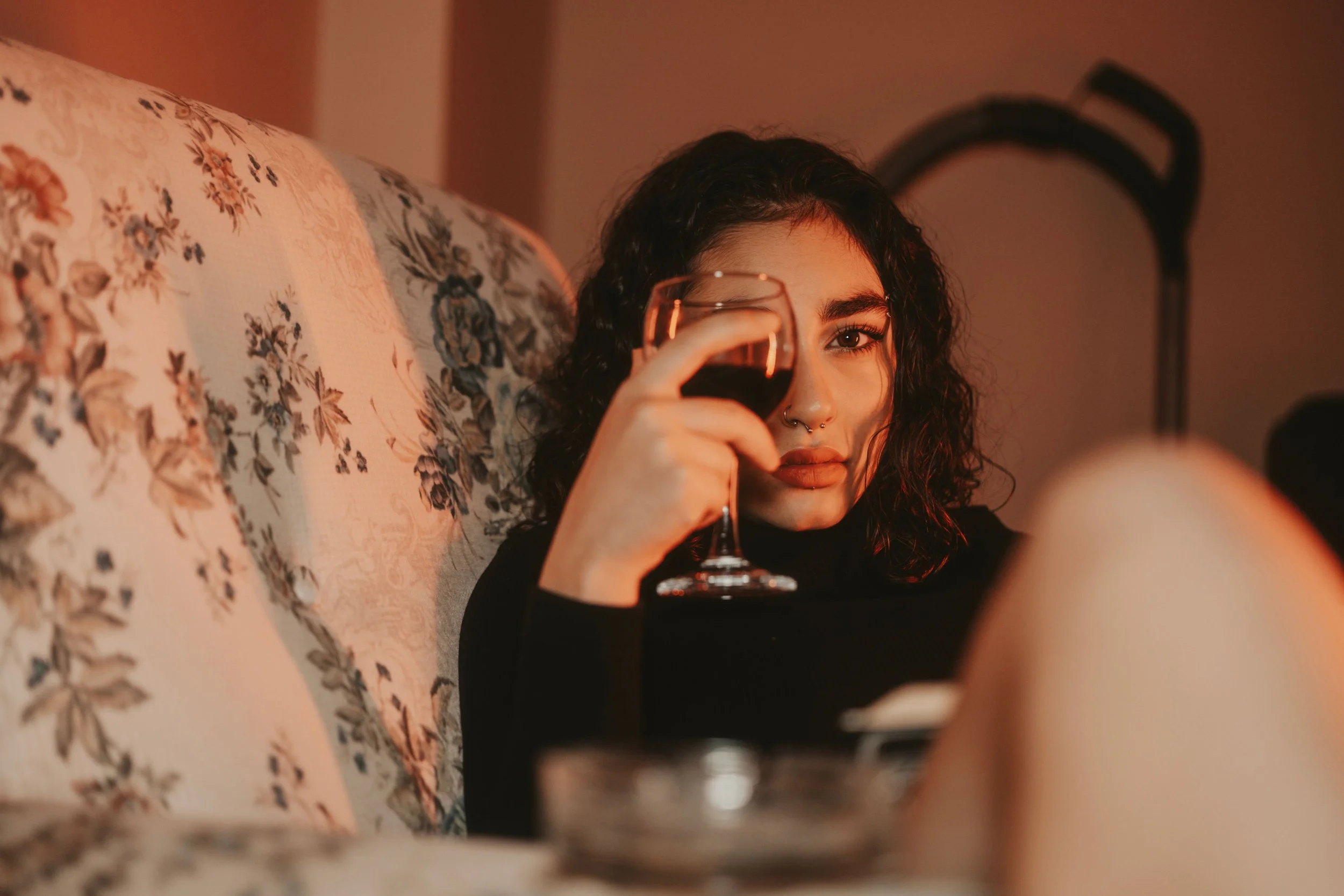 Woman drinking a glass of wine alone on her sofa