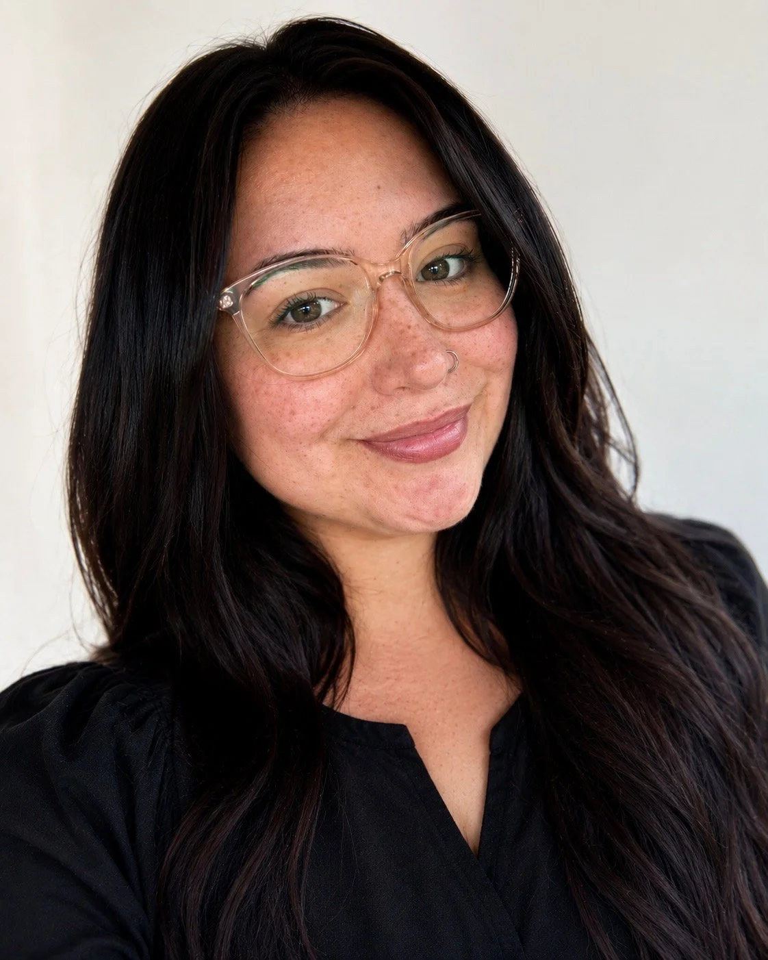 A woman with dark hair wearing glasses