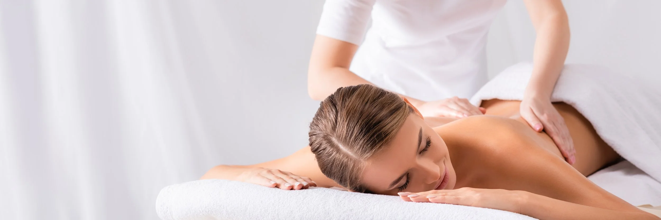 Woman receiving a back massage in a spa or massage therapy setting.