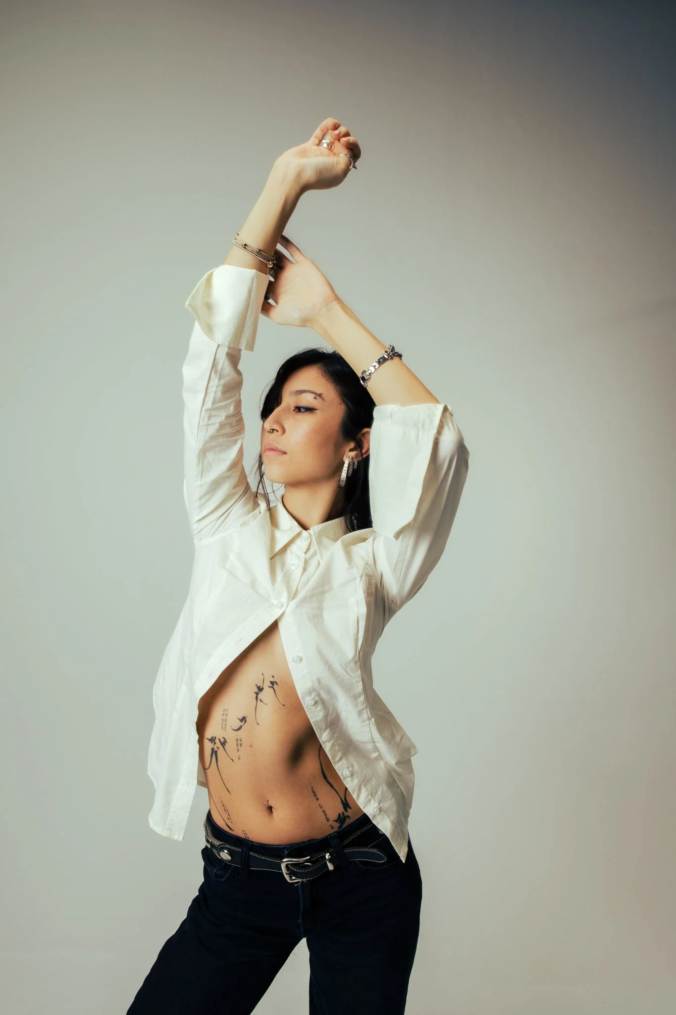 Person wearing a light blue suit and sunglasses, with a platinum wig, standing outdoors at dusk.