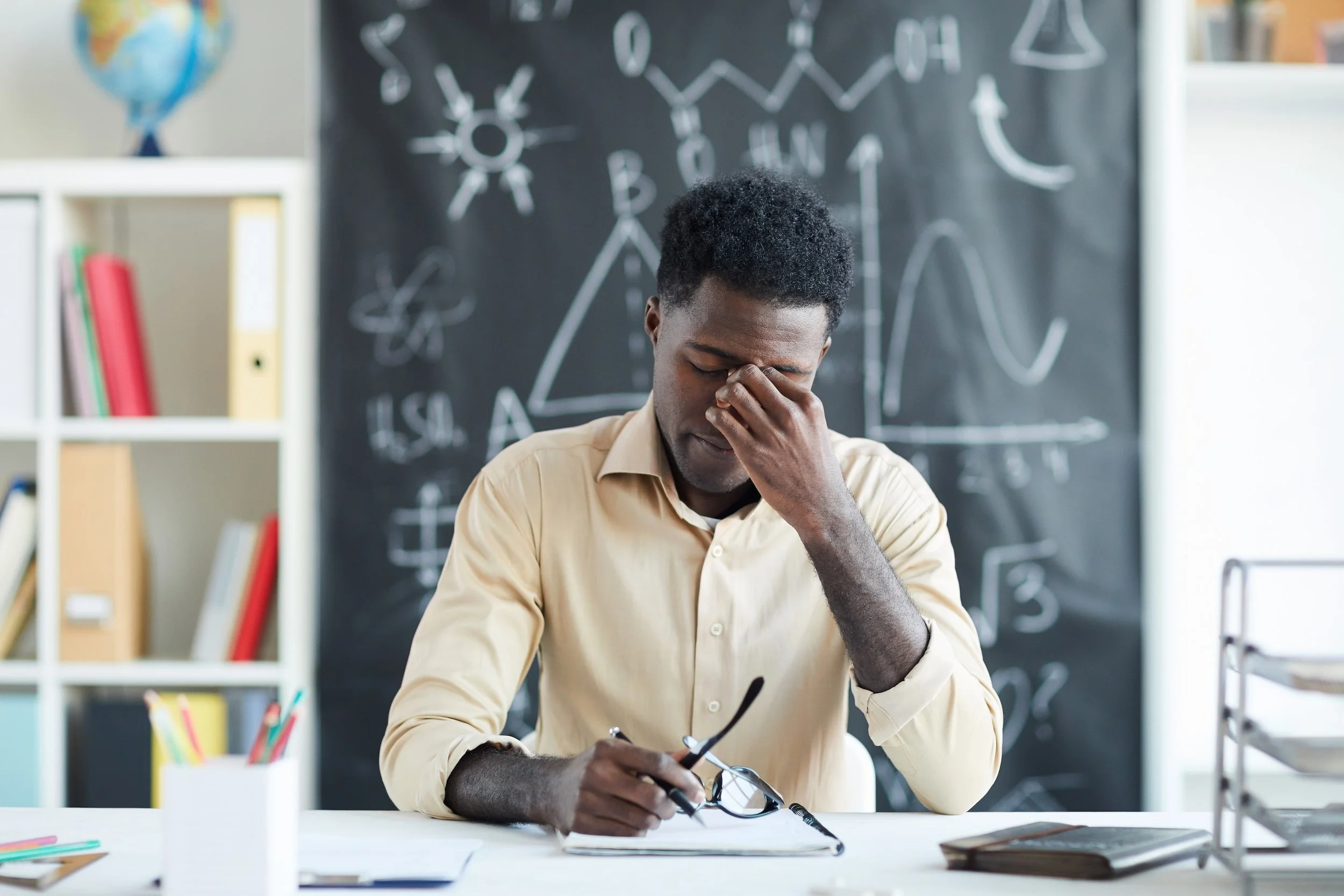 A teacher struggling at his desk