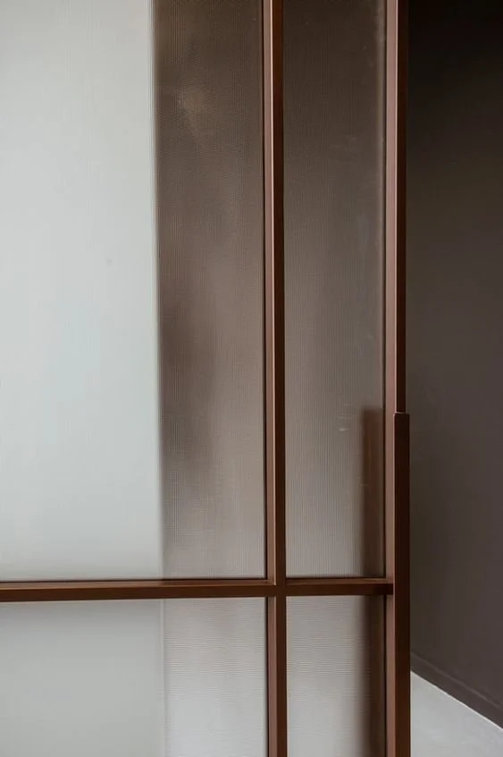 Close-up of a sliding door with frosted glass panels and a wooden frame.
