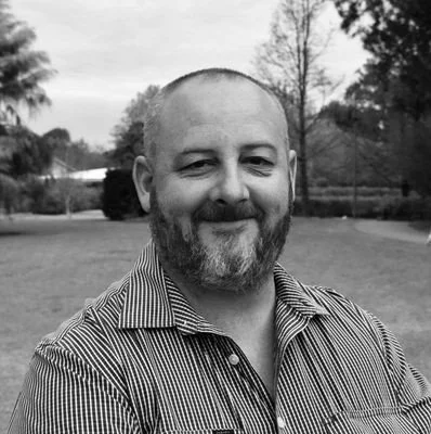 A black and white portrait of Simon Davis, a senior advisor of the AI-driven bushfire management company FiSci