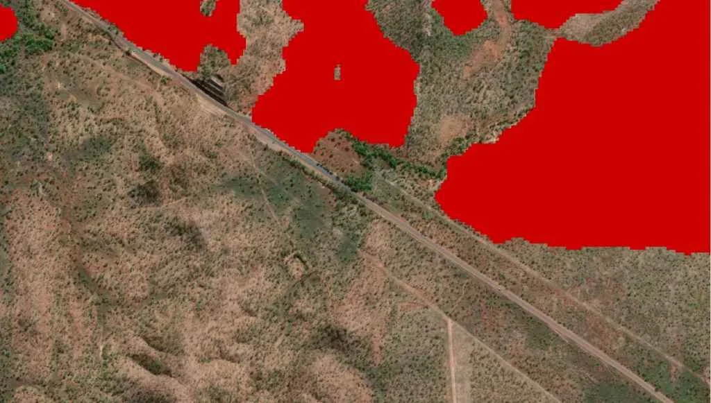FiSci's deep learning algorithm red overlay precisely mapping a fire scar boundary as it meets a clump of trees along the Stuart Highway, demonstrating high-resolution landscape feature detection.